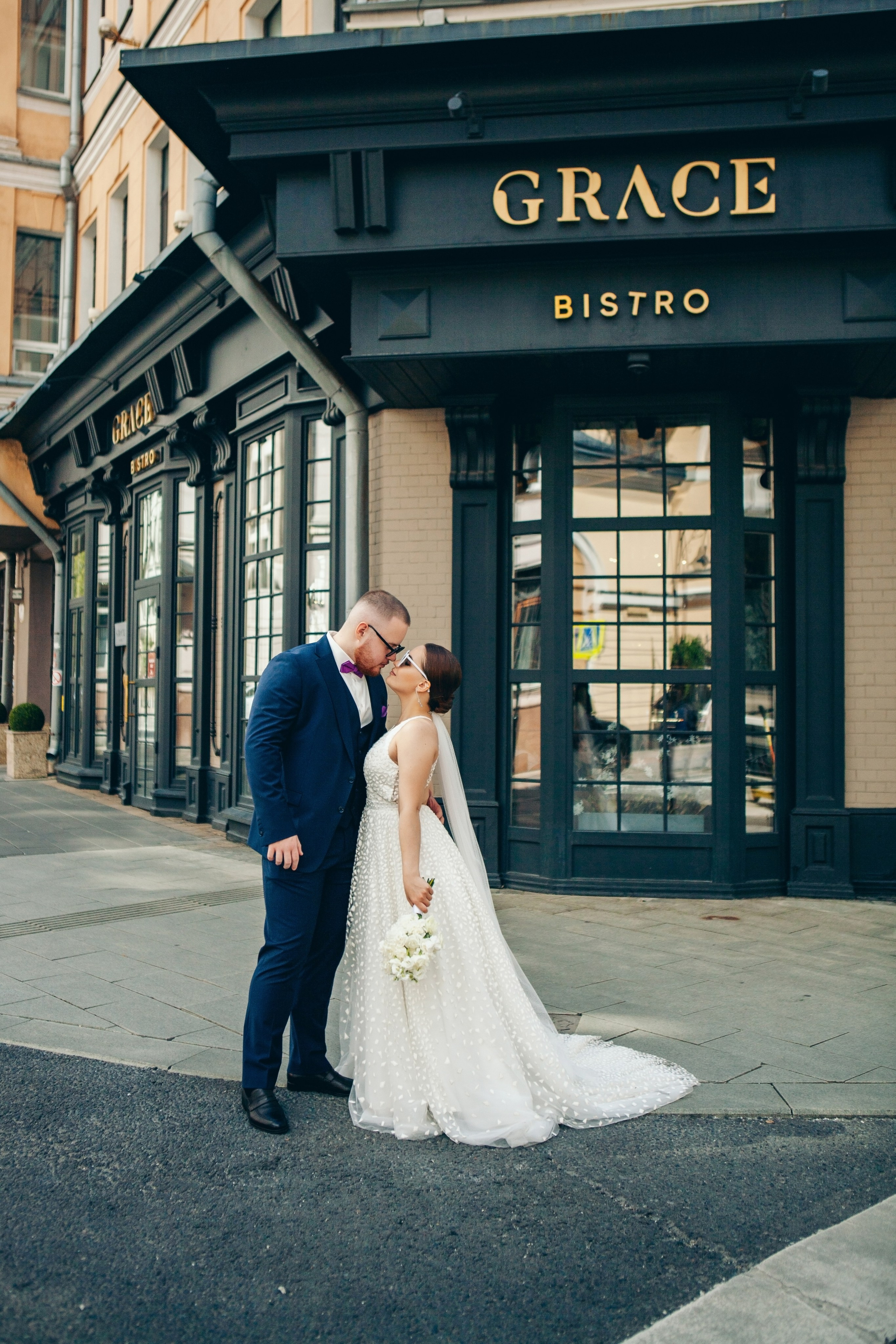 поцелуй молодоженов на фоне бистро grace в центре москвы