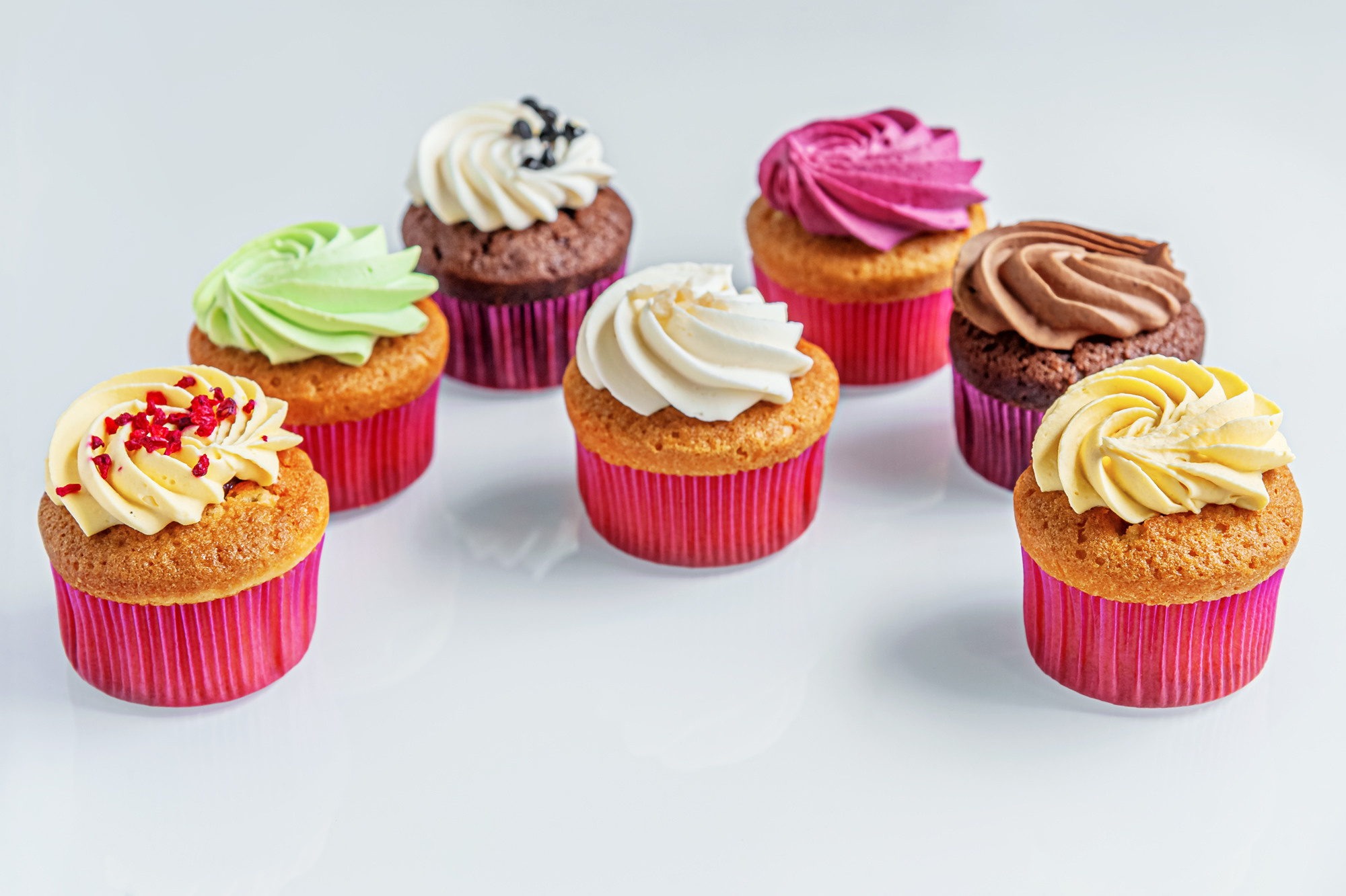 assorted cupcakes on a white glass surface
