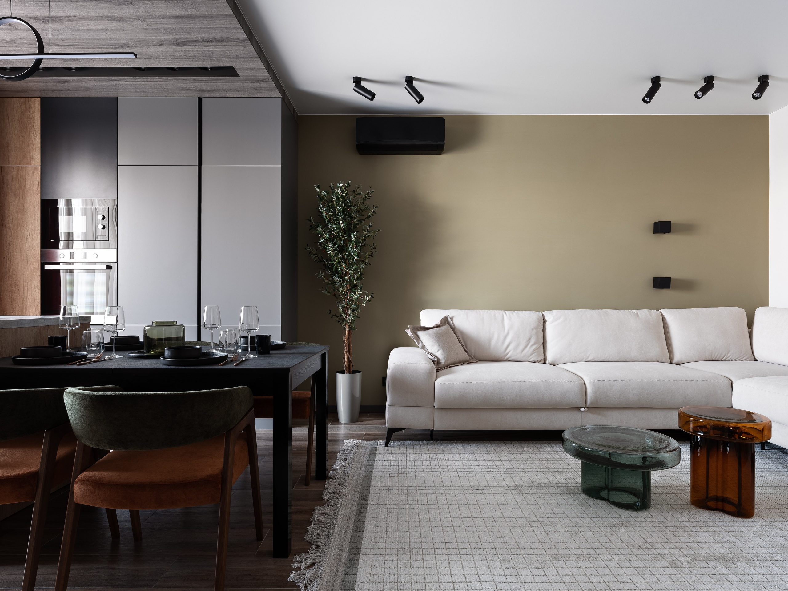 Кухня-гостиная с современной мебелью, большим светлым диваном, черным обеденным столом и стильным декором; автор проекта Екатерина Мищенко, фотограф Сергей Денисенко.