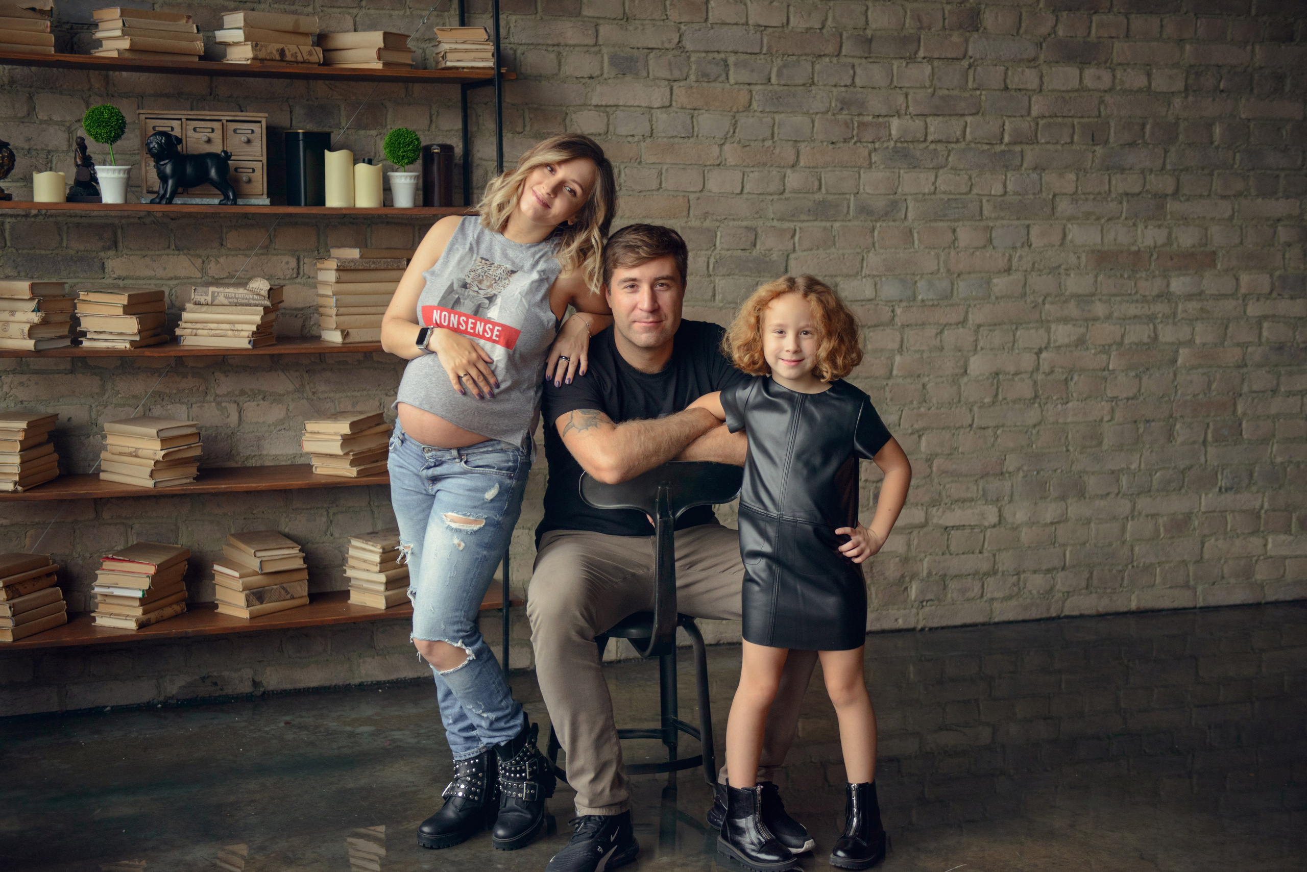 Family photo shoot with a pregnant woman in a loft studio, rock and roll style