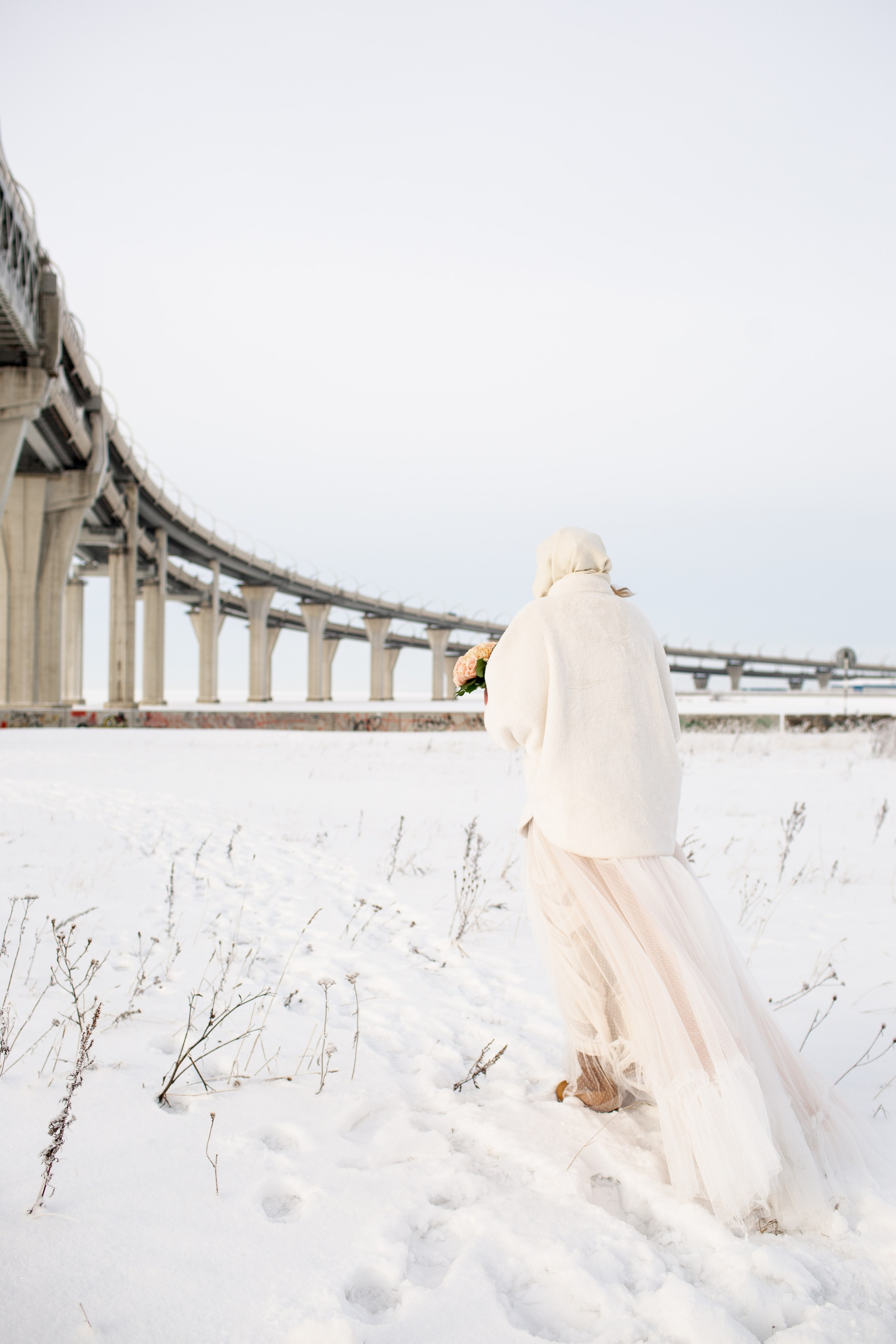 Зимняя свадьба в Санкт-Петербурге, невеста в свадебном платье на фотопрогулке в снежной локации