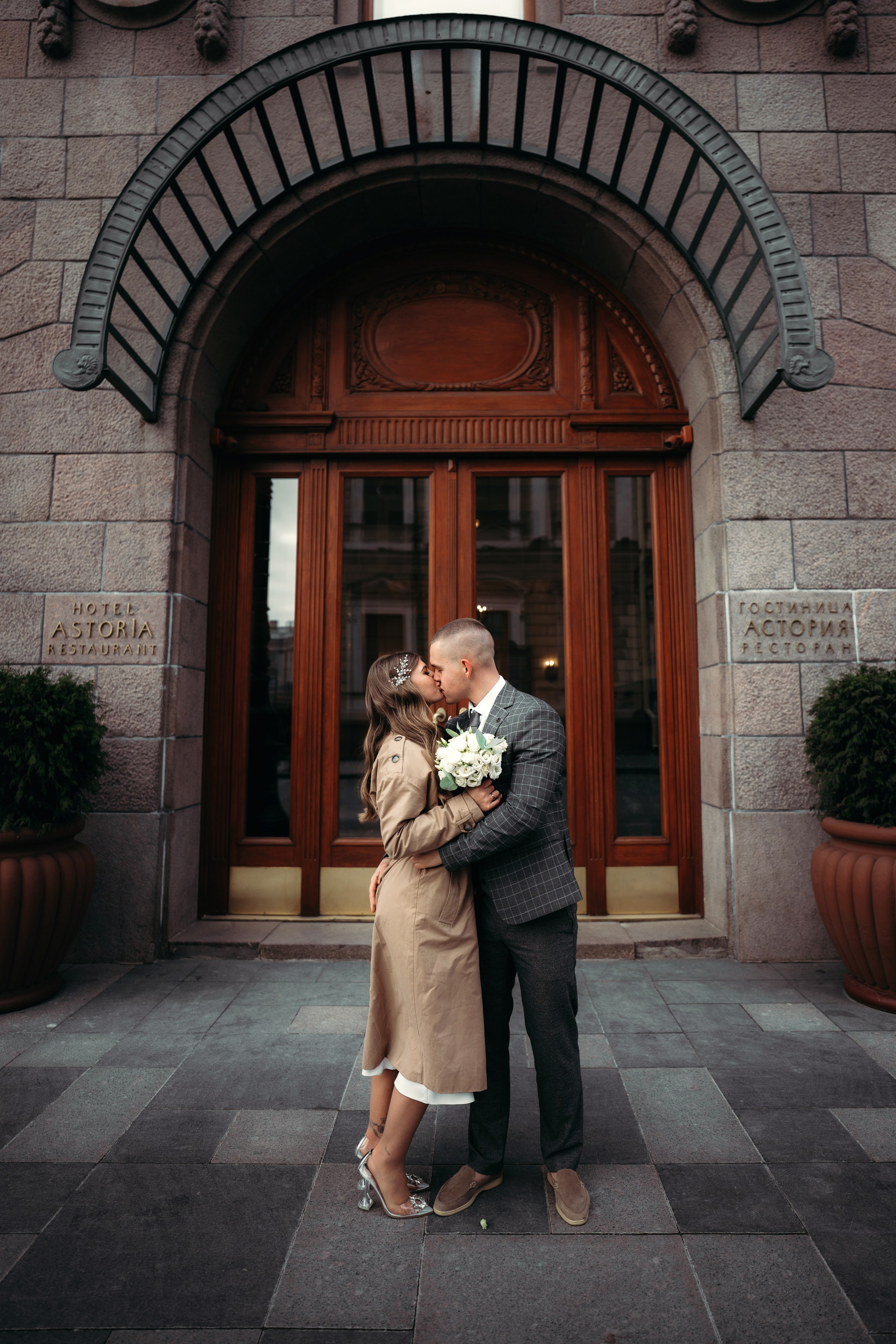 жених и невеста целуются около входа в гостиницу Астория.Свадебная фотосессия у Астории.