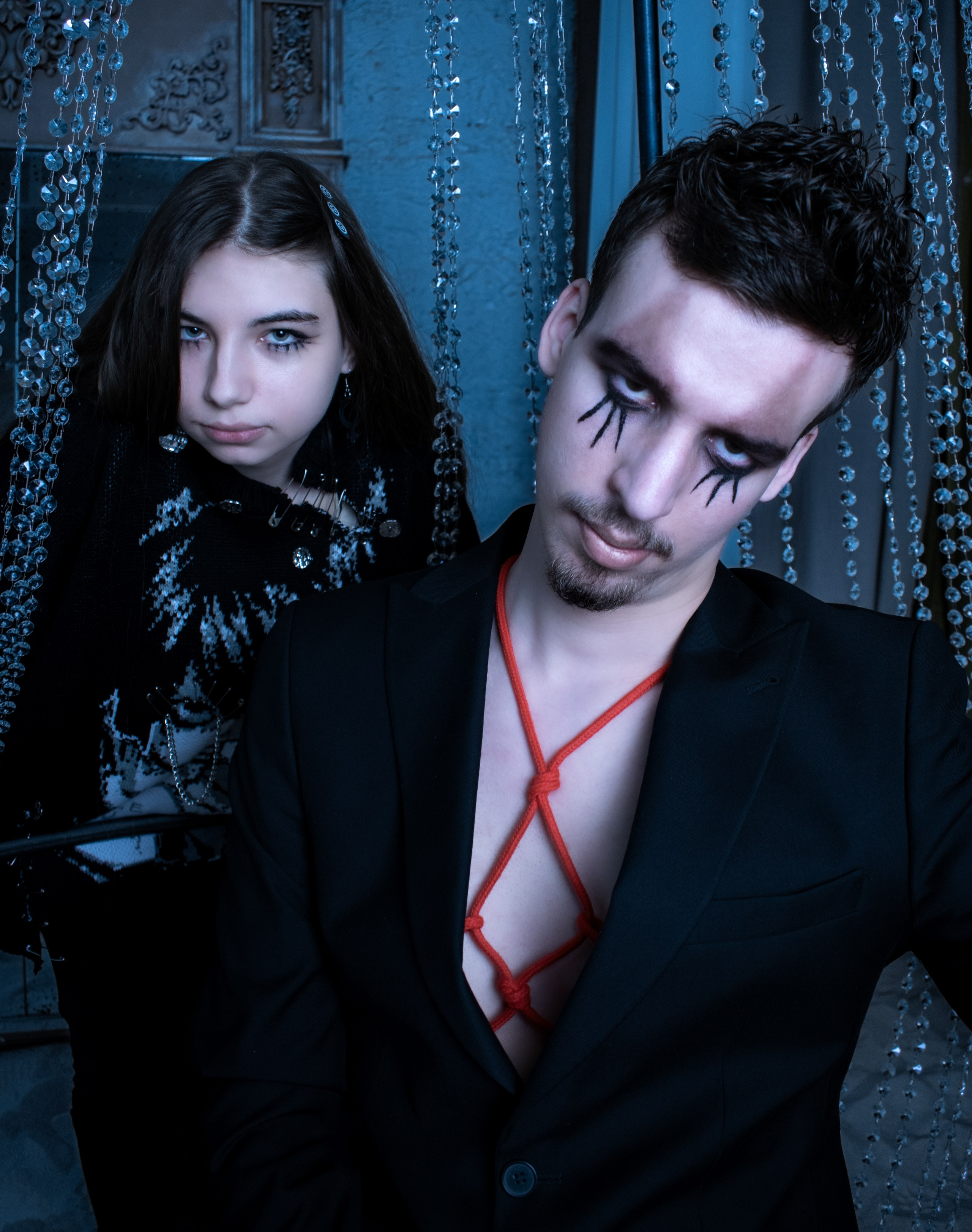 Девушка и парень в панк-стиле позируют на фоне хрустальной люстры