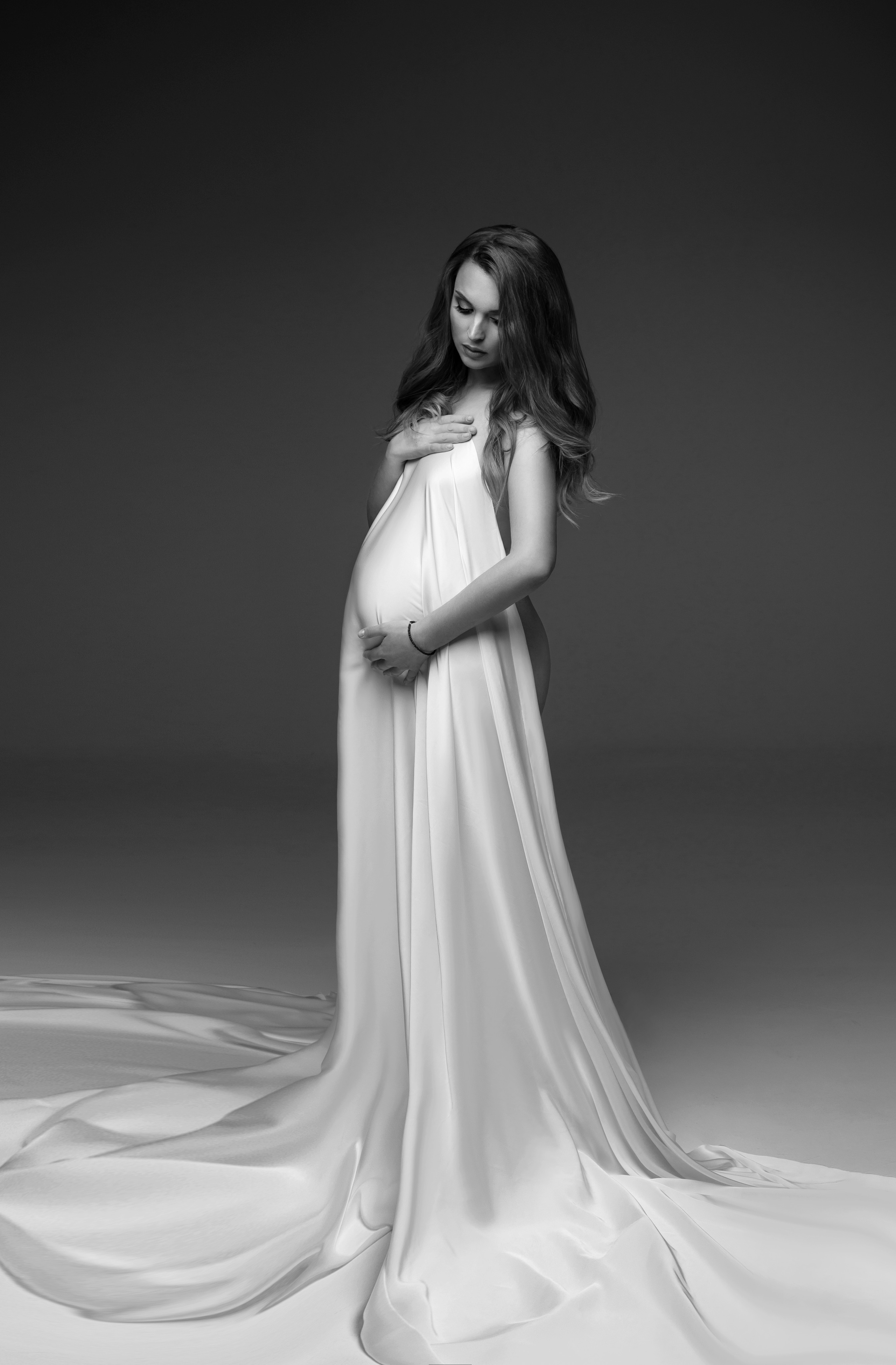 Стильная фотосессия беременной девушки в белой шелковой ткани.