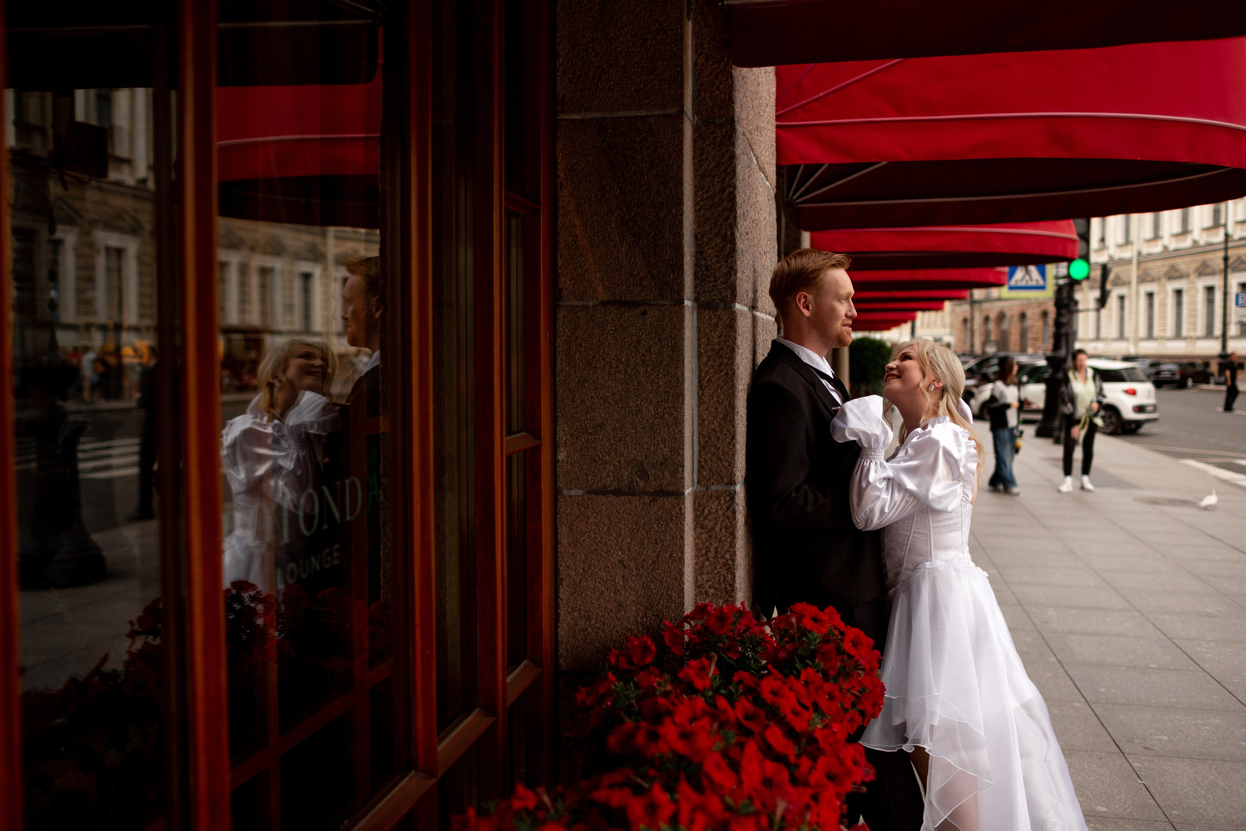 Жених в черном смокинге и невеста в белом платье со шлейфом.