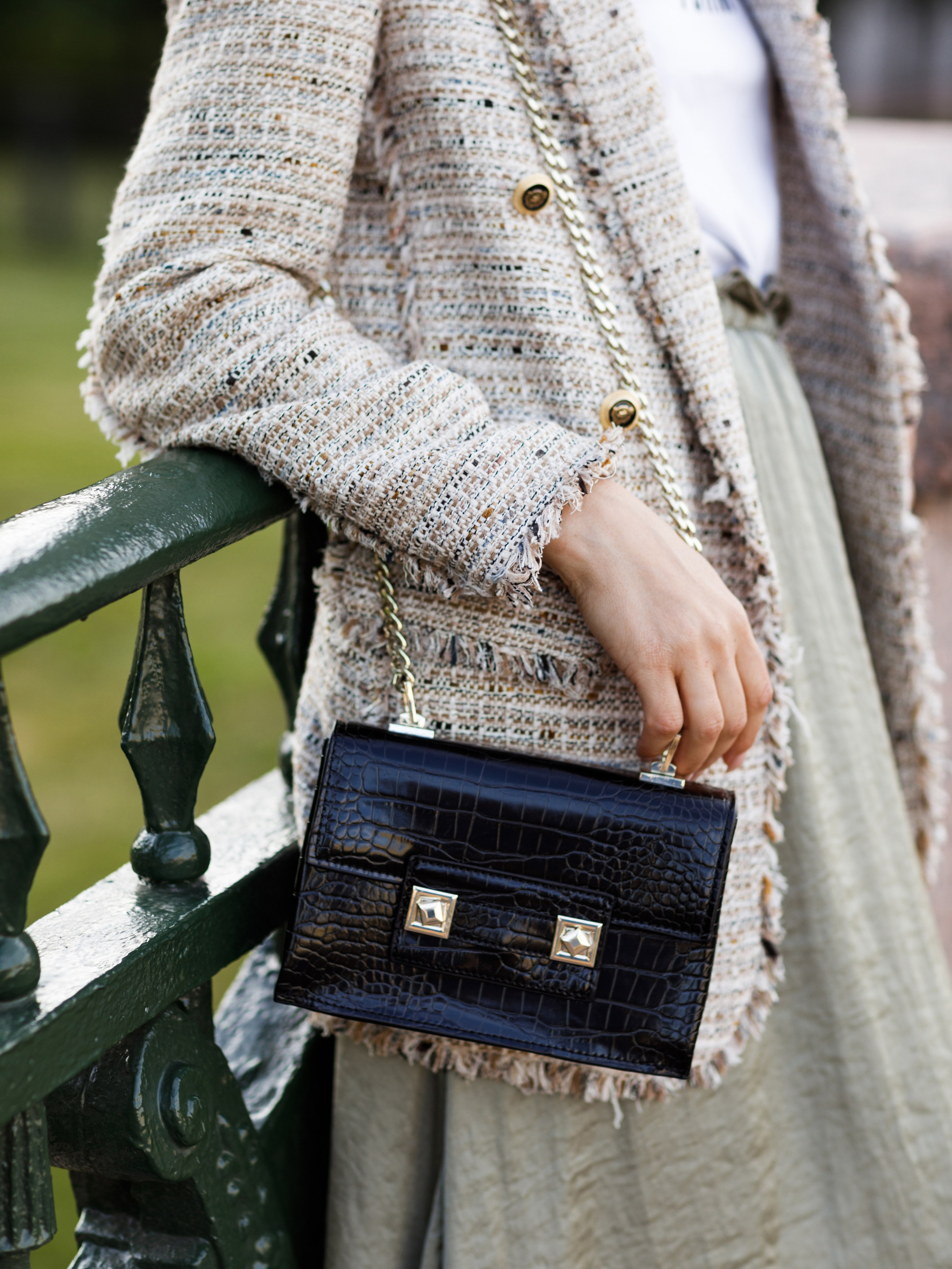 Кожаная сумка висит на плече девушки