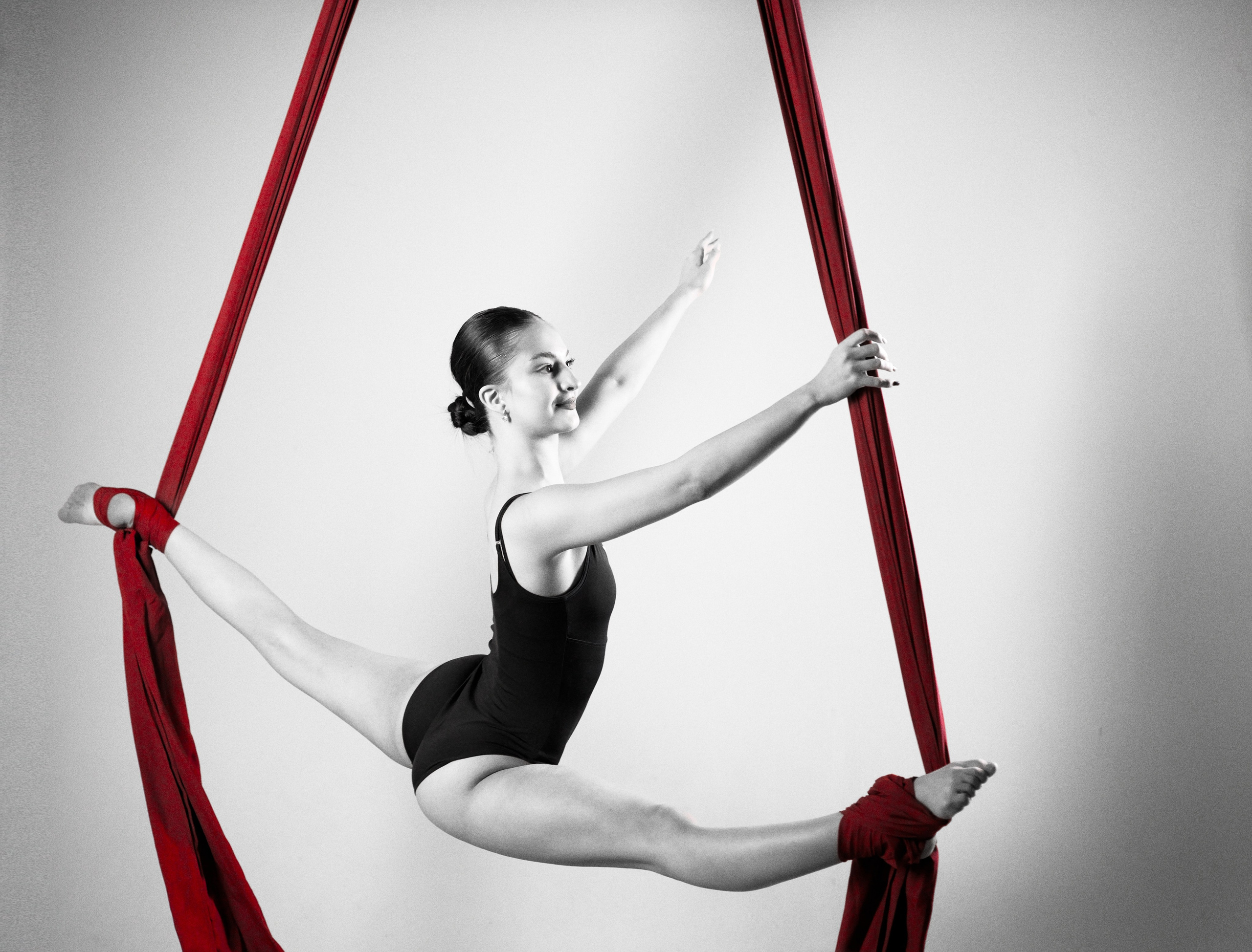 Эстетичный горизонтальный шпагат в воздухе: фиксация гибкости и линий на полотнах, спортивная фотосессия.