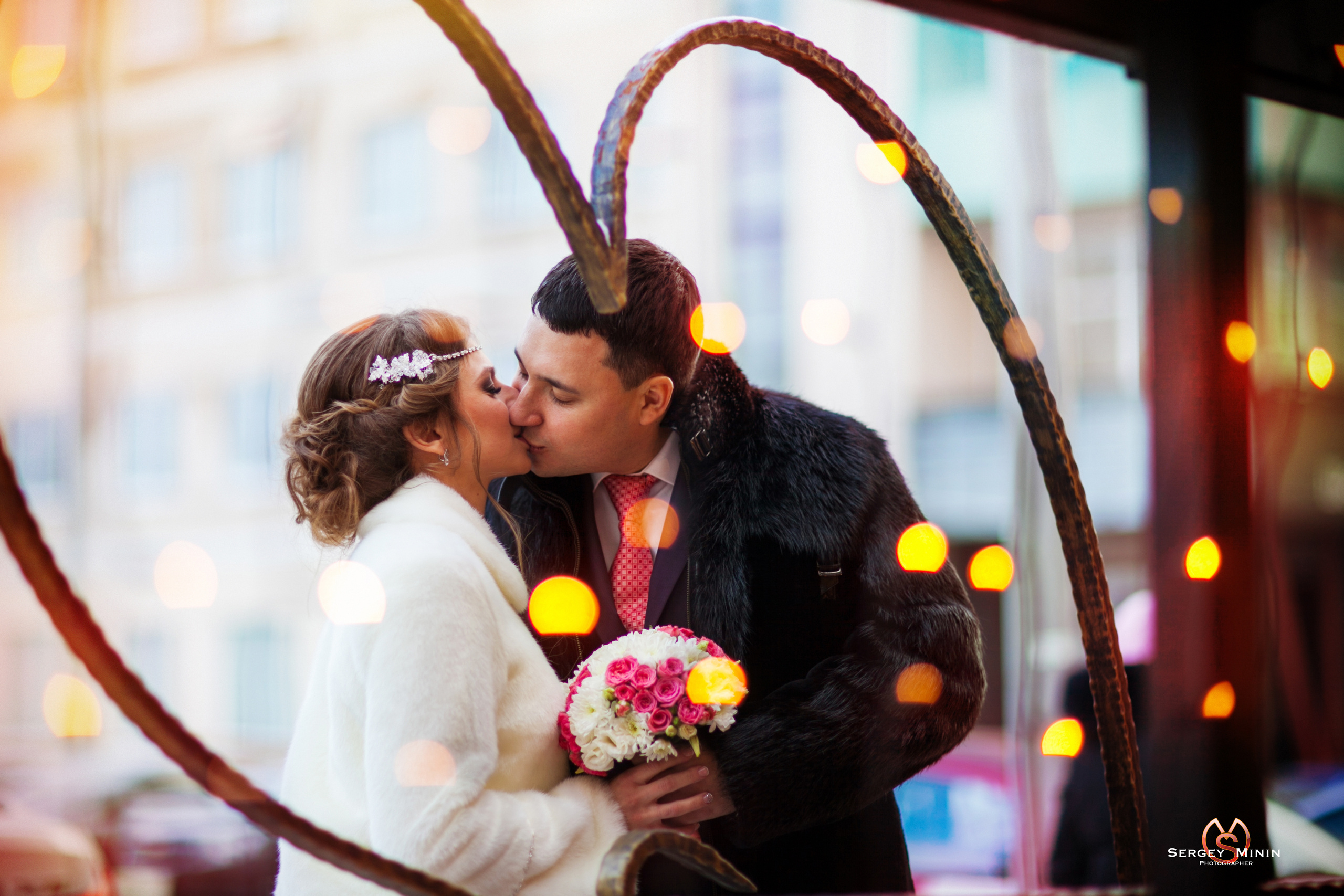 Уличная свадебная фотосессия жениха с невестой зимой на фоне красивого города Екатеринбурга