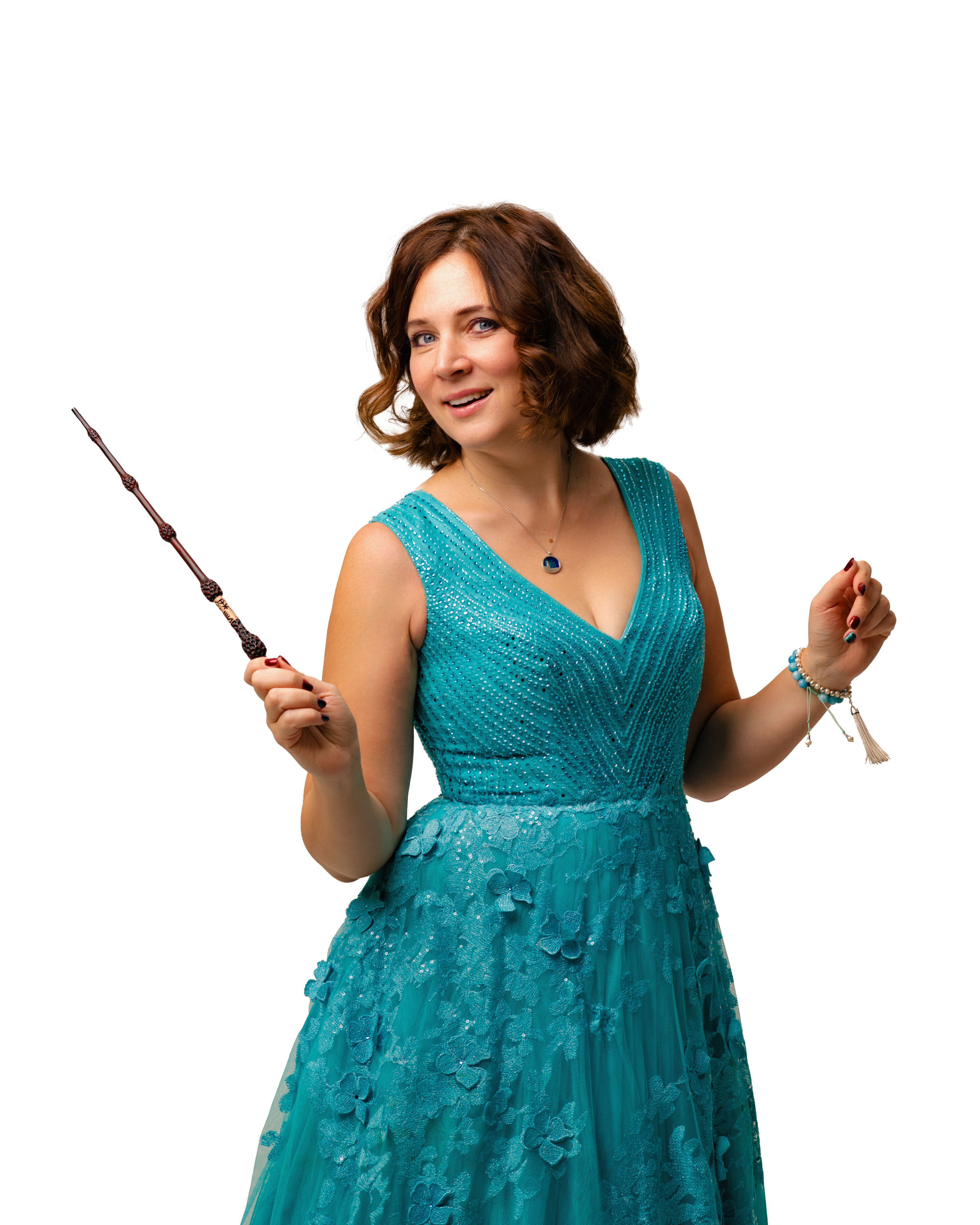 Женщина в изумрудном, открытом платье с волшебной палочкой в руках на белом фоне