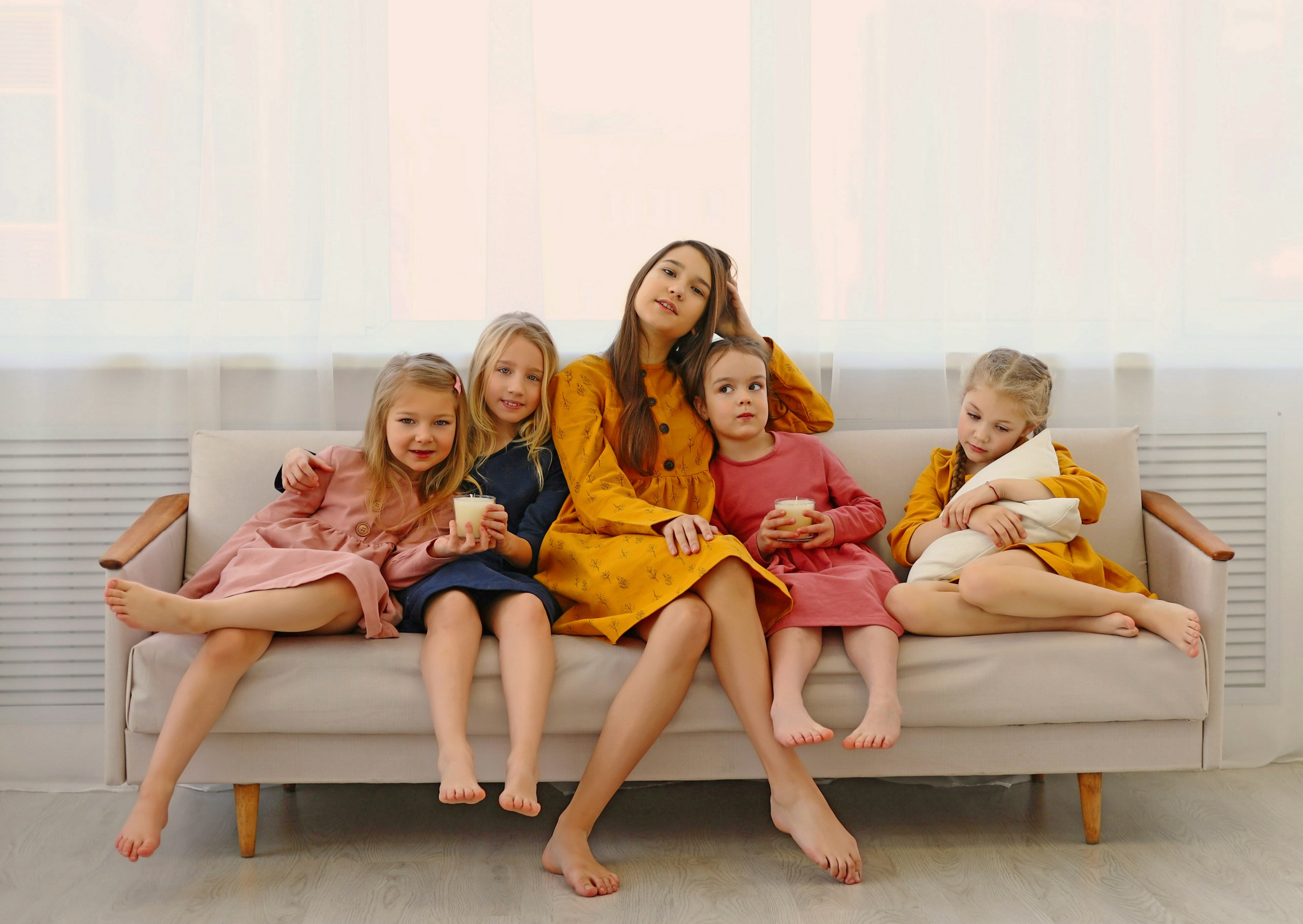 Девочки в платьях на диване