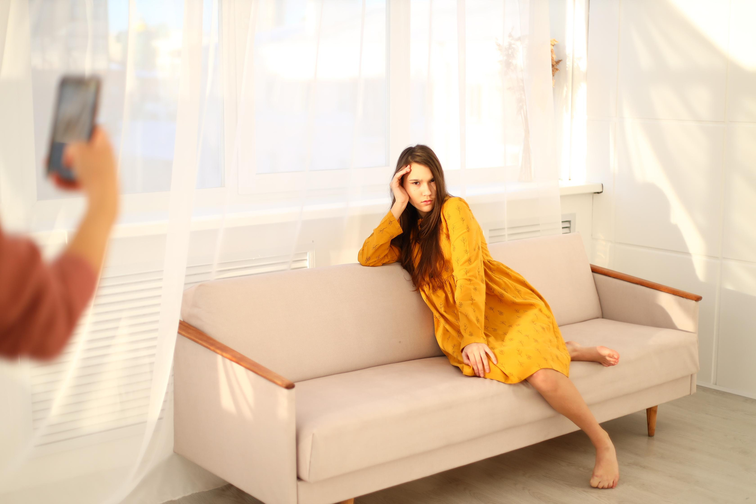 Девушка в жёлтом платье на диване