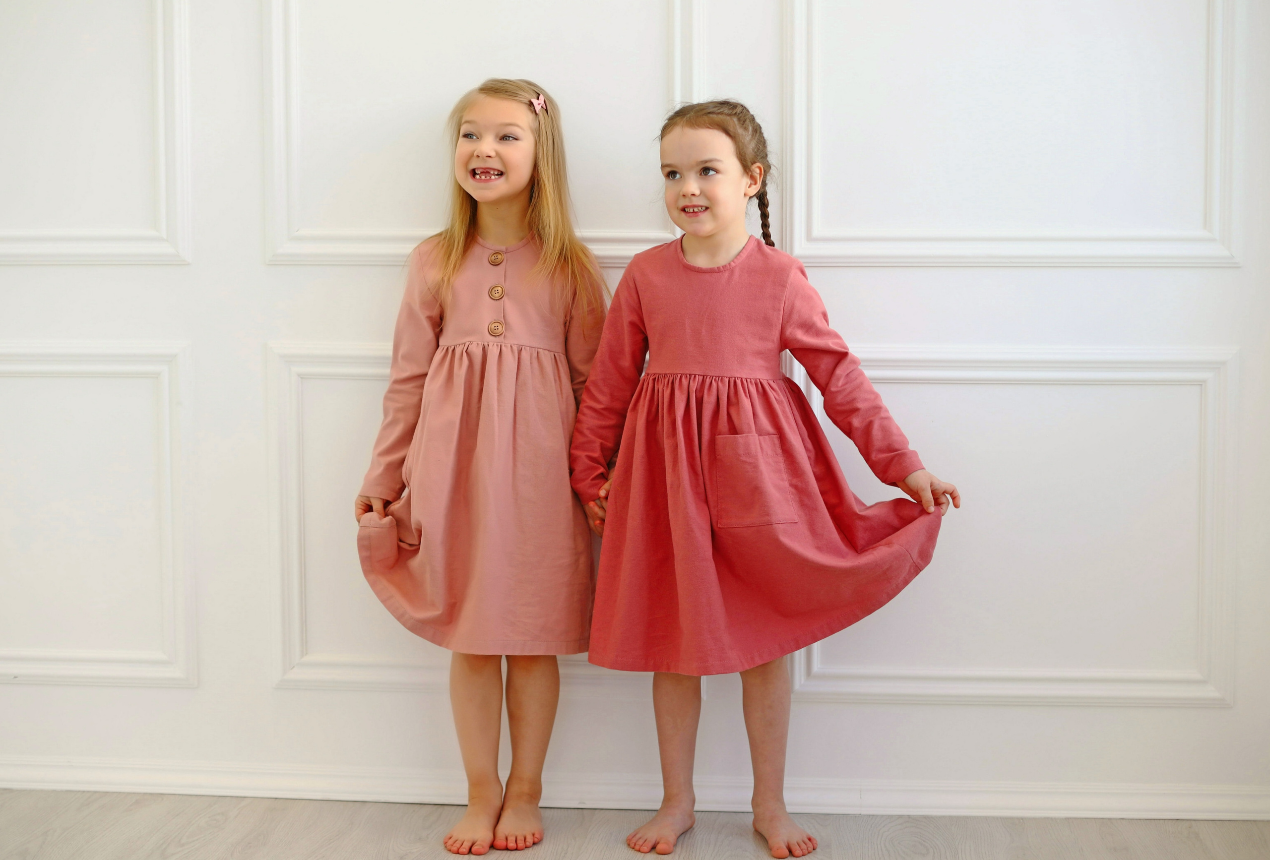 Две девочки в платьях улыбаются