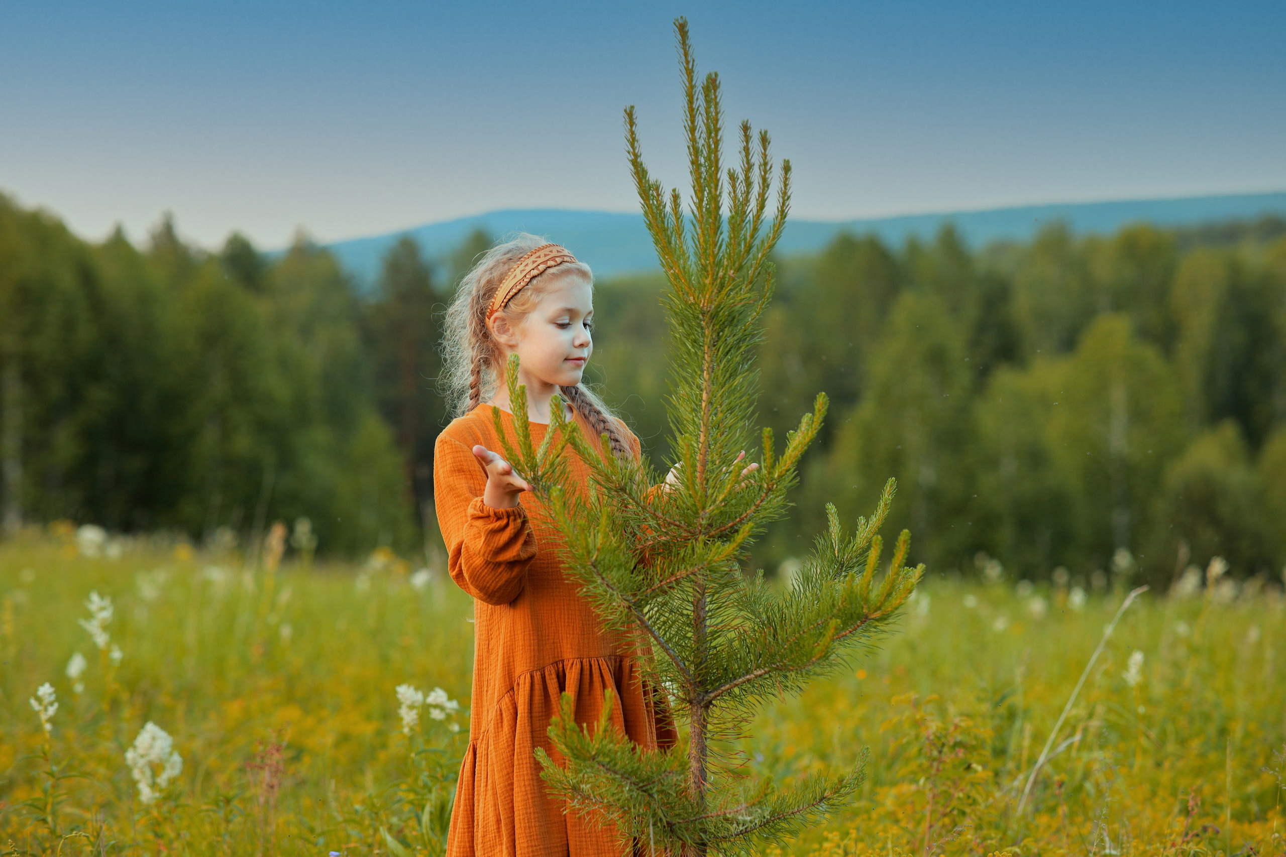 Девочка в платье трогает деревоДевочка в красном платье трогает ёлку. Модель Алиса Алексеева