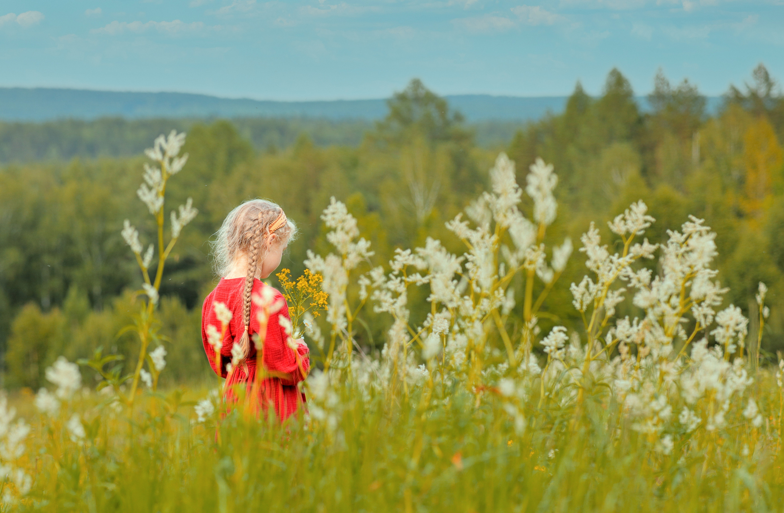 Девочка в красном платье стоит на горе. Девочка в красном платье трогает ёлку. Модель Алиса Алексеева