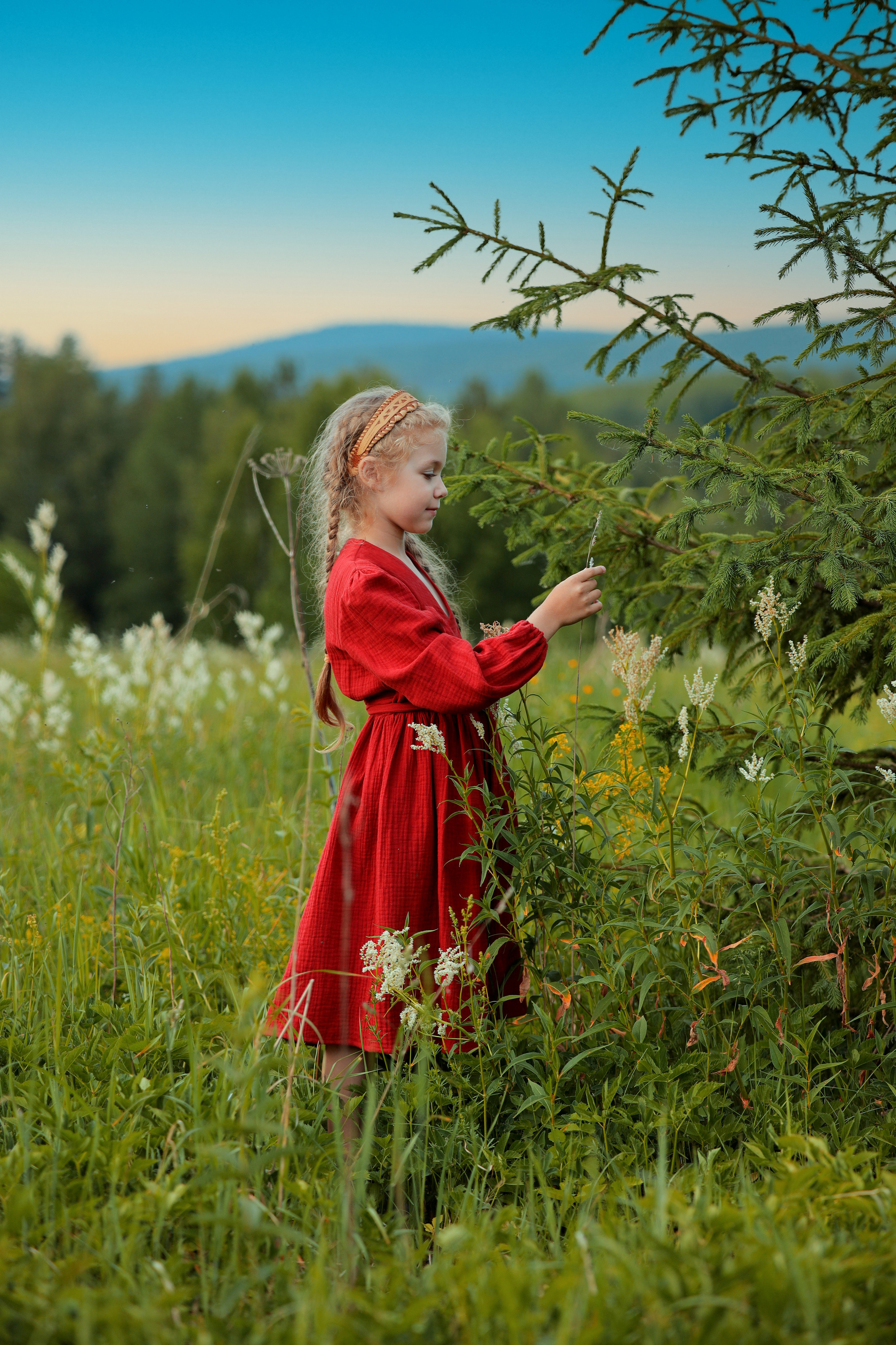 Девочка в красном платье трогает ёлку. Модель Алиса Алексеева