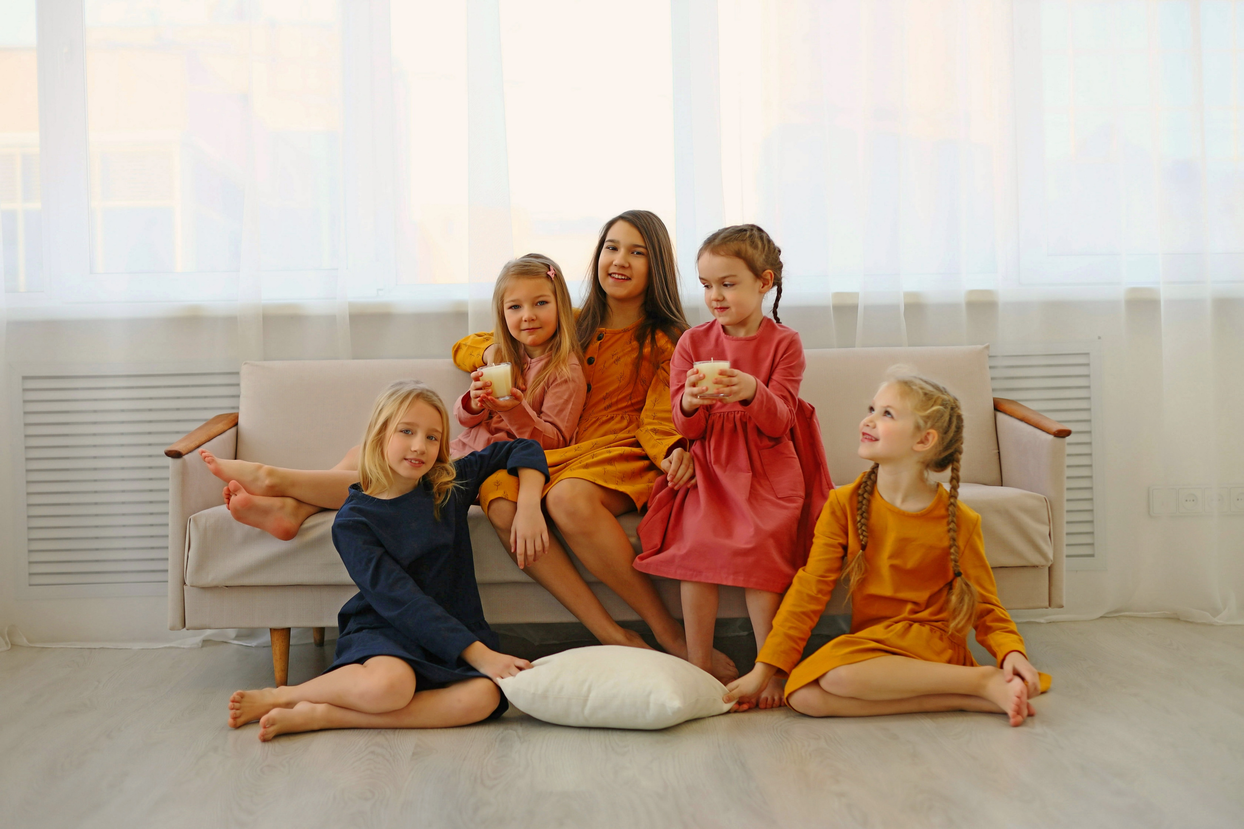 Девочки в платьях на диване. Девочка в красном платье трогает ёлку. Модель Алиса Алексеева