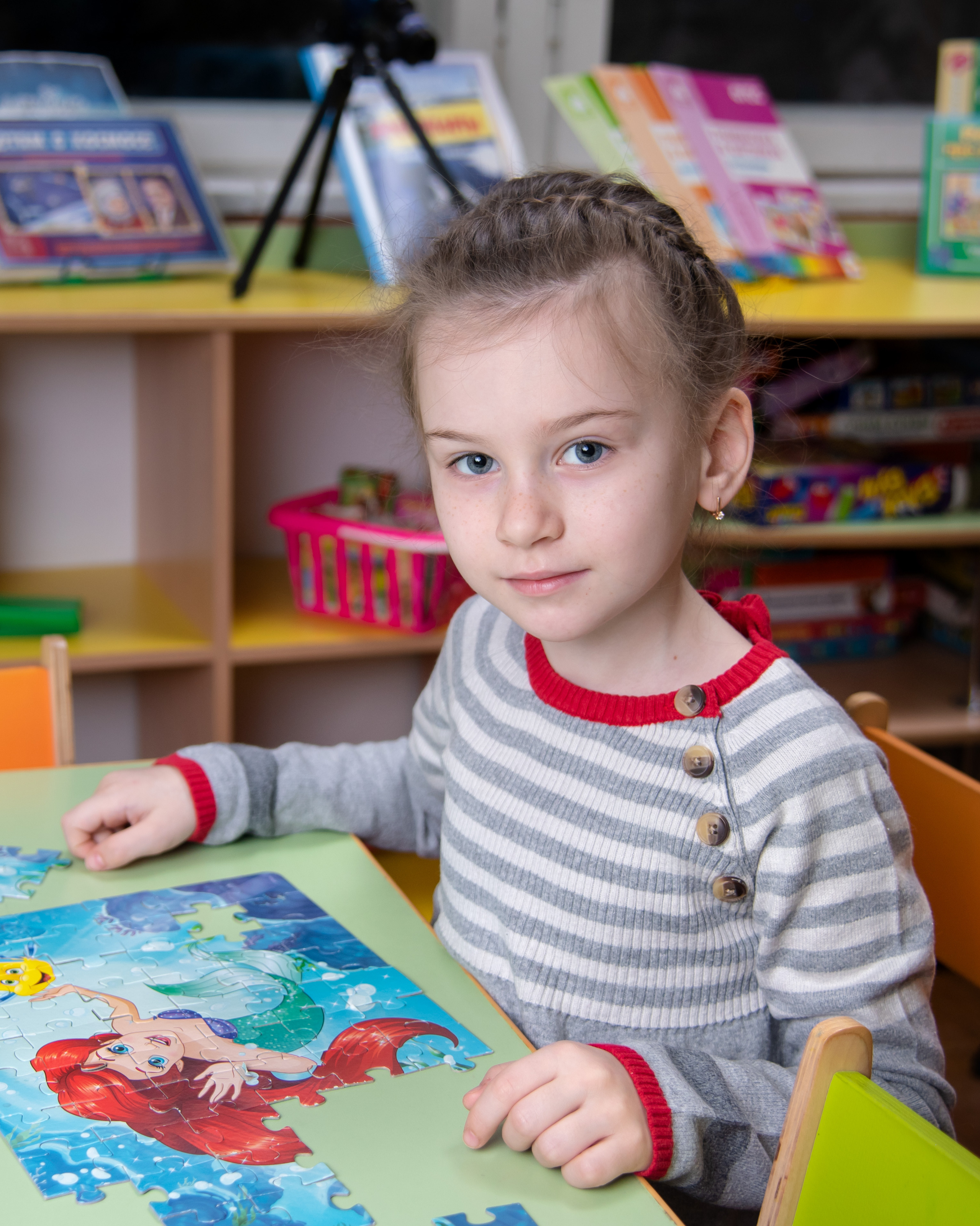 Девочка собирает пазлы в детском саду Золотая рыбка