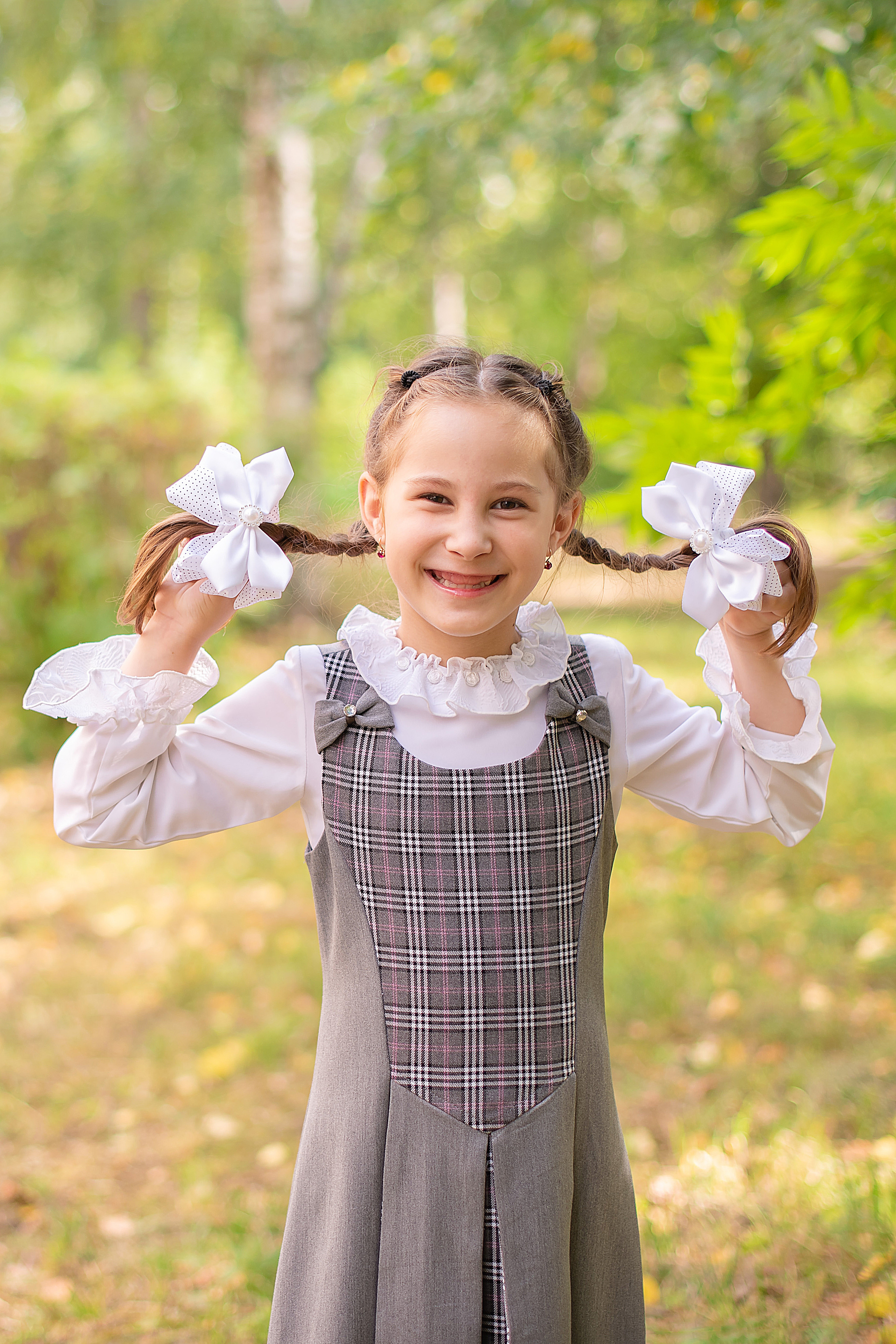 Девочка с двумя косичками. Милая беззубая улыбка