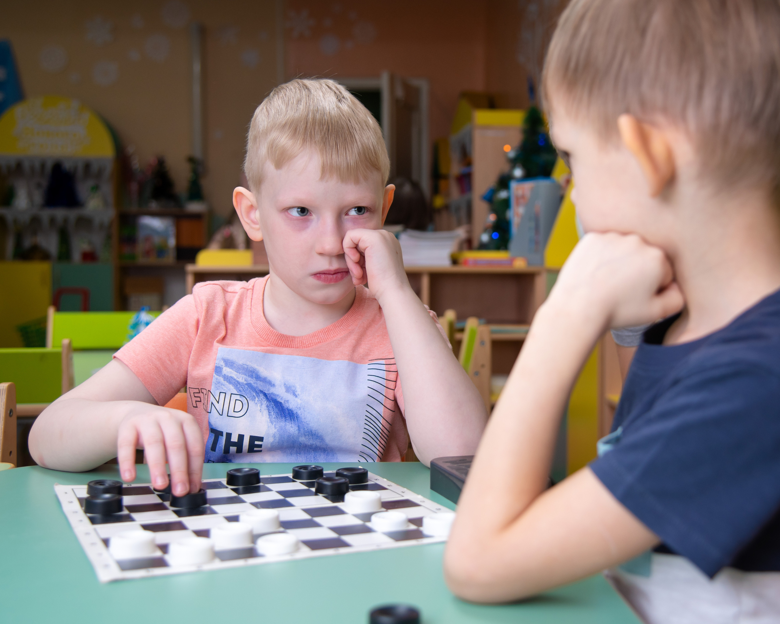 Мальчики играют в шахматы в детском саду золотая рыбка