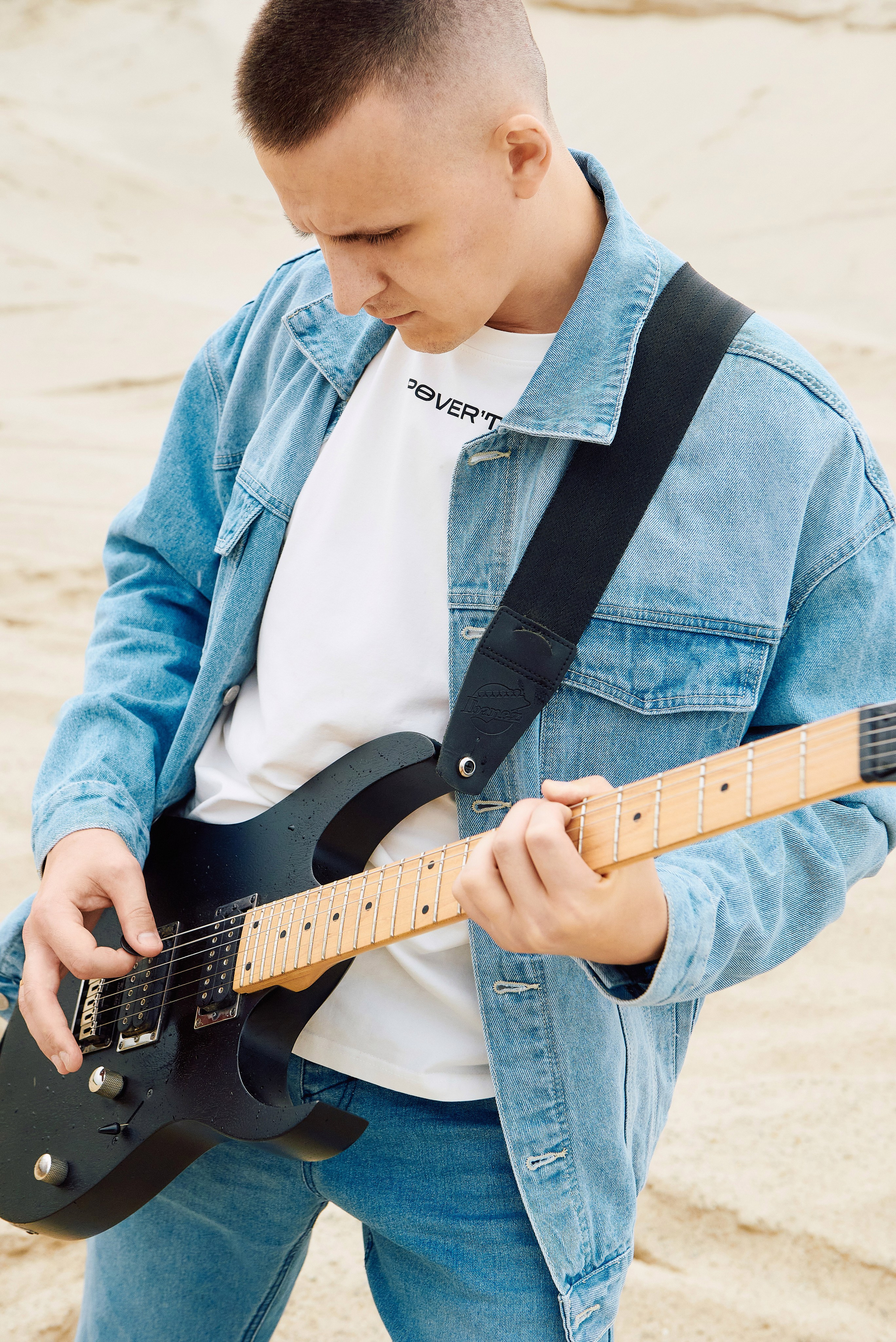 Парень играет на гитаре в пустыне