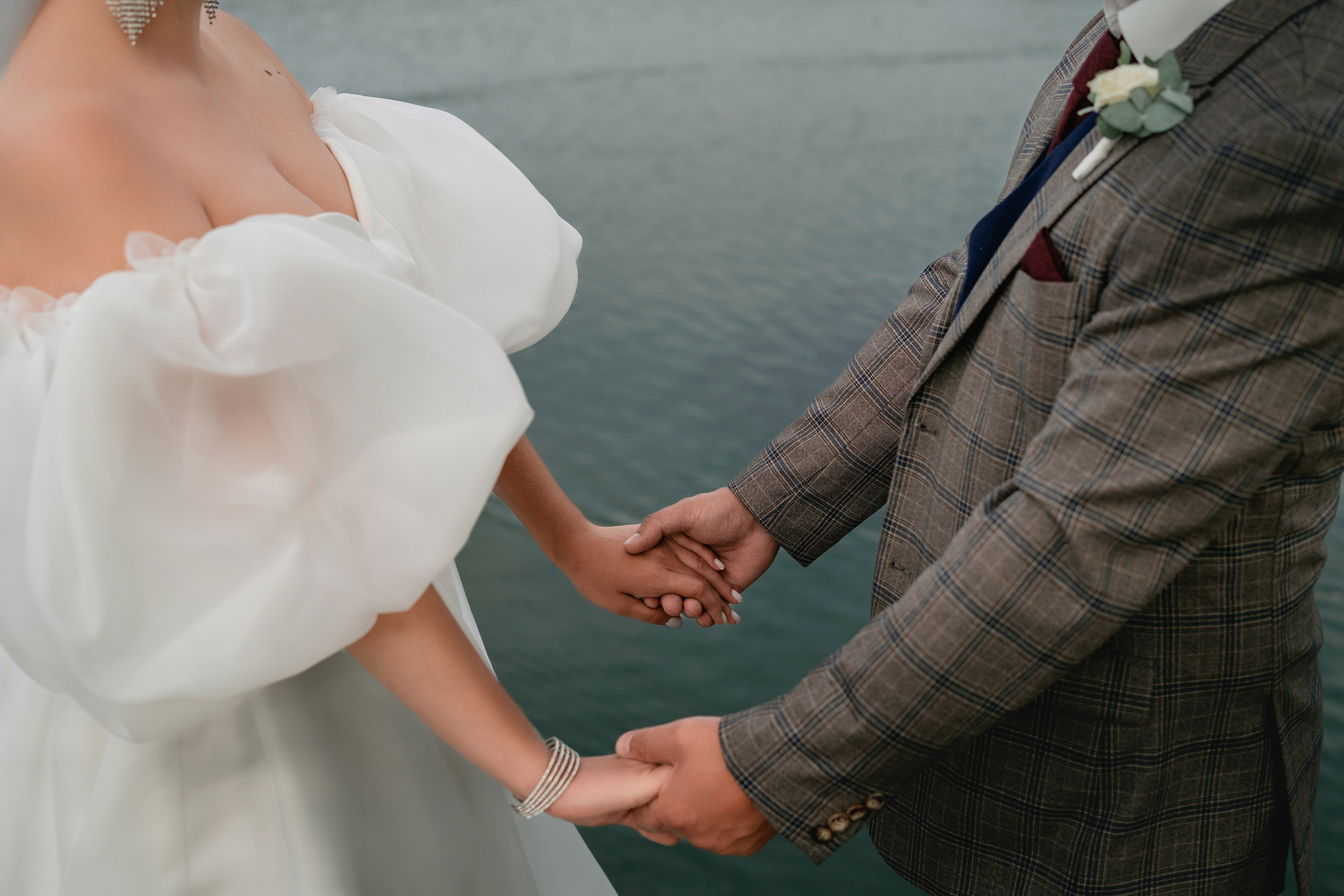 Жених и невеста держатся за руки на фоне природы Краснодарского края  