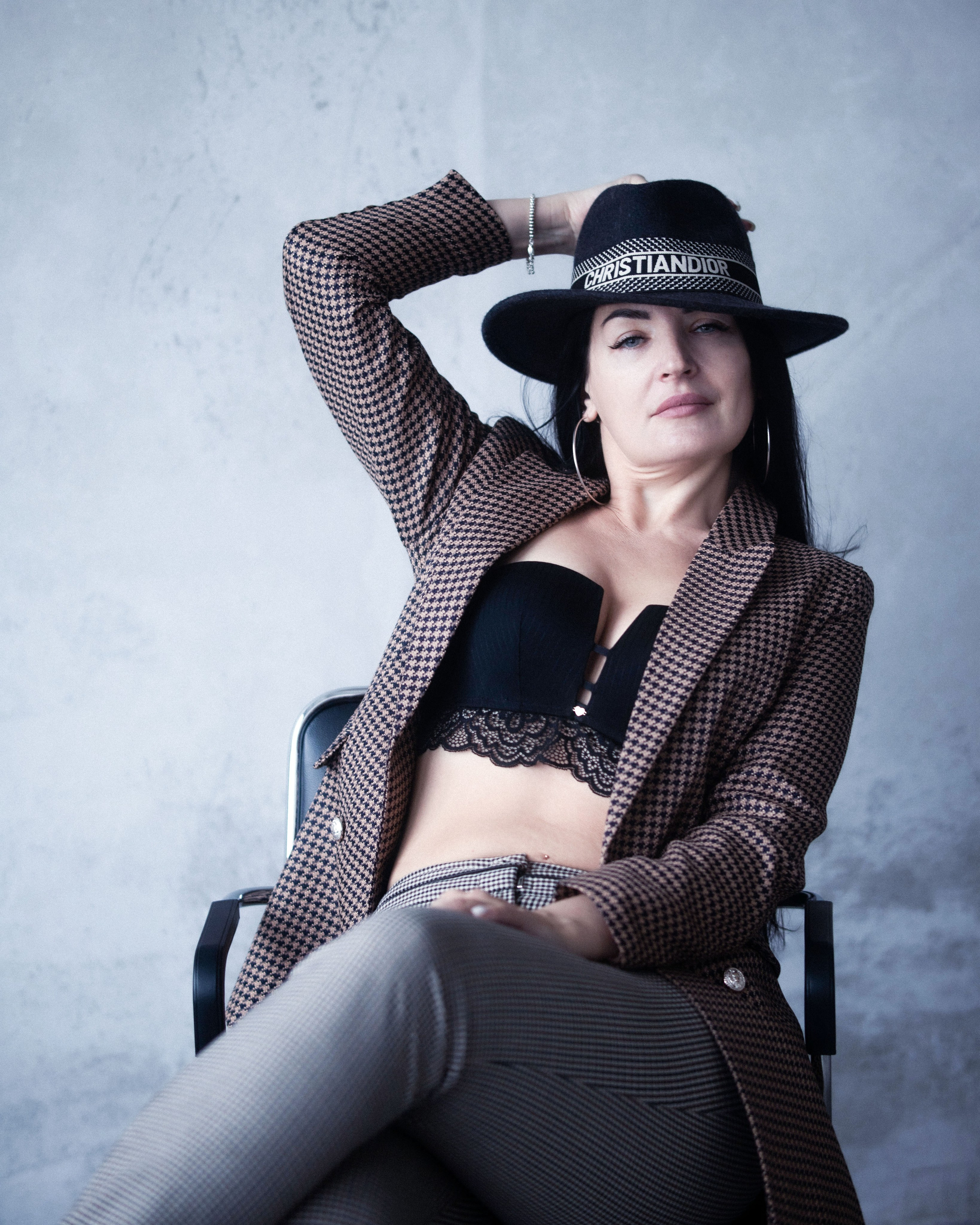 женщина сидит в жакете и шляпе