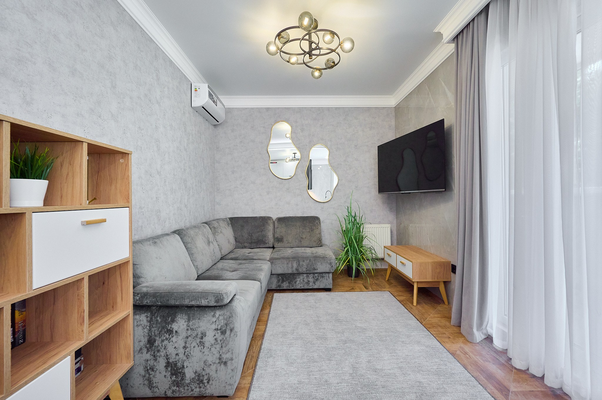 серый диван зеркала столик с ящиками телевизор