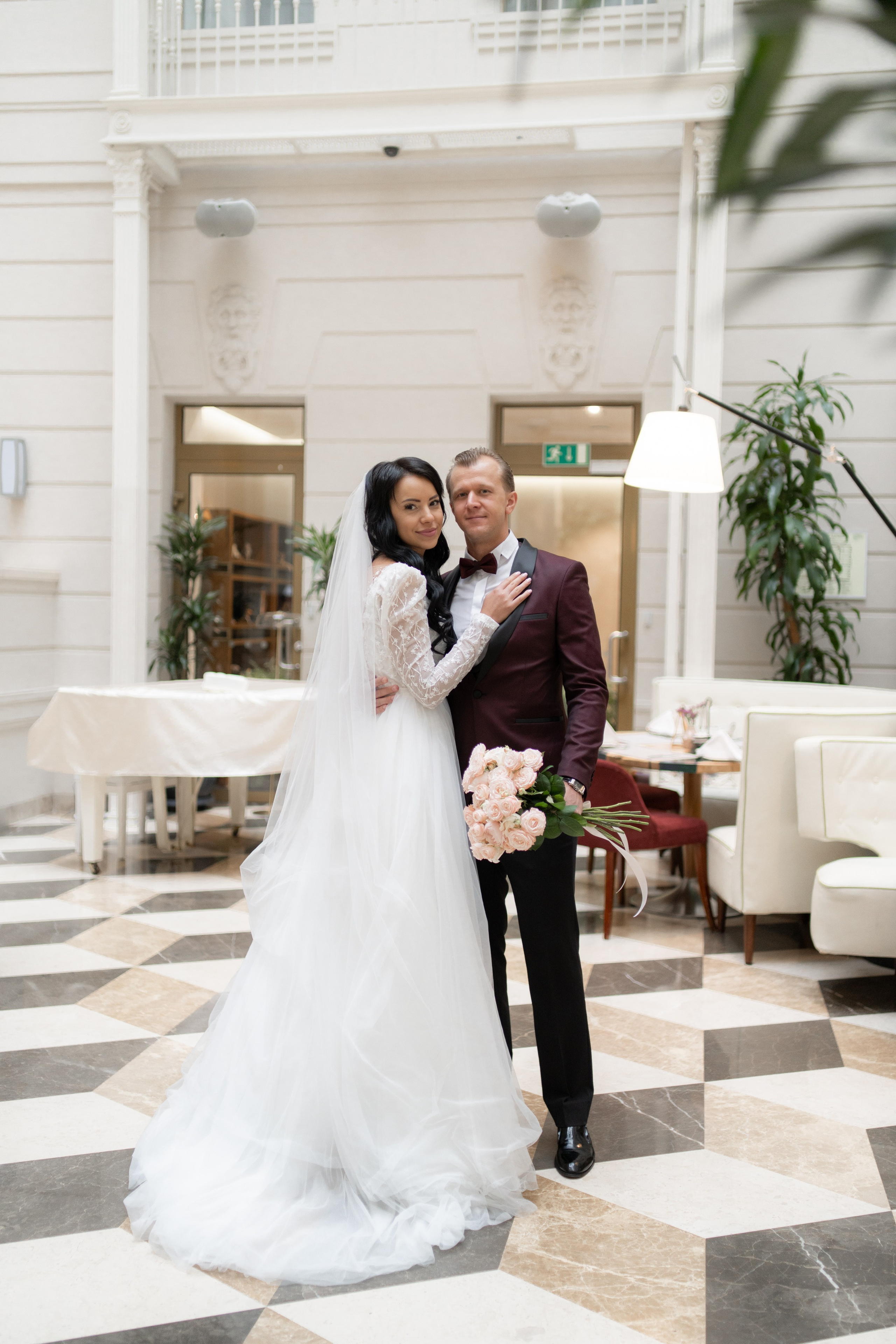 невеста и жених обнимаются в холле в отеле Индиго на свадебной фотосессии