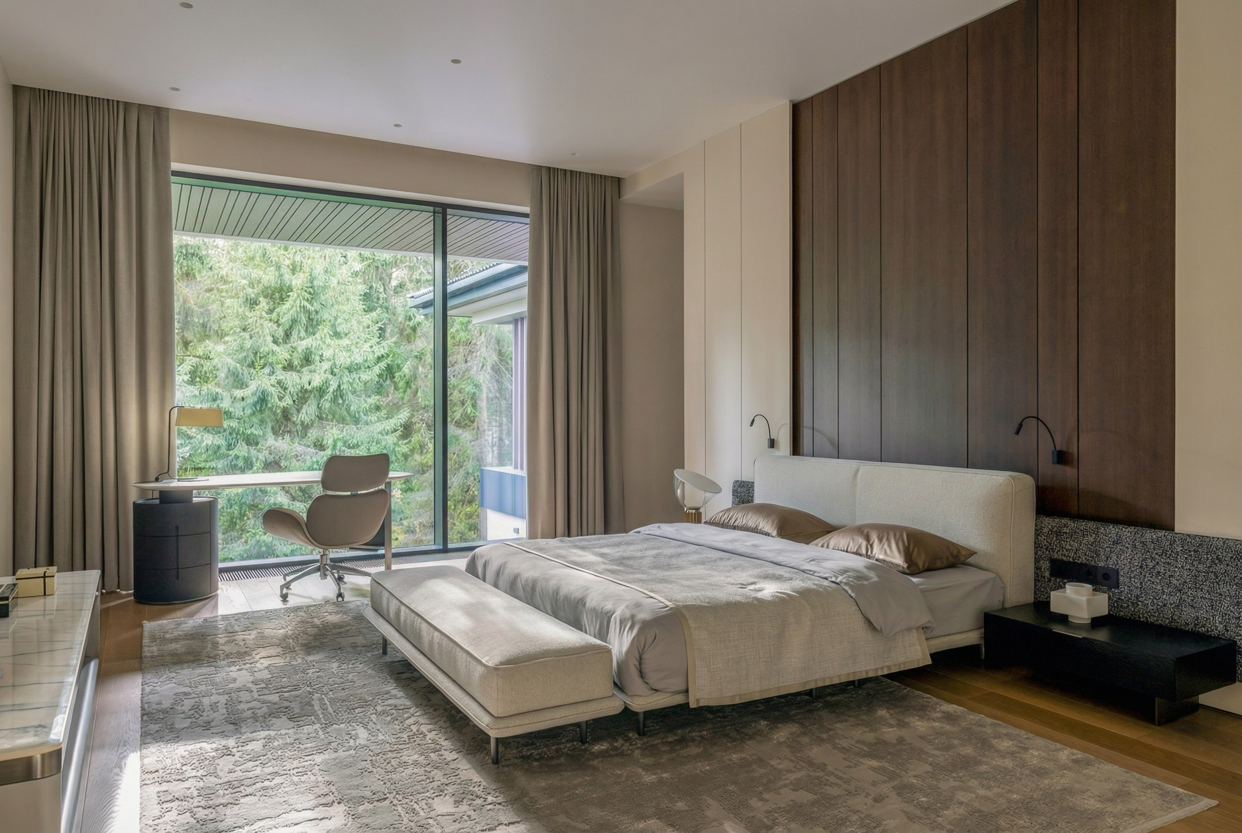 Панорамный интерьер мастер-спальни с панорамным окном на лес, дизайнерской кроватью и рабочим местом у окна, проект Валерии Котович в Подмосковье.