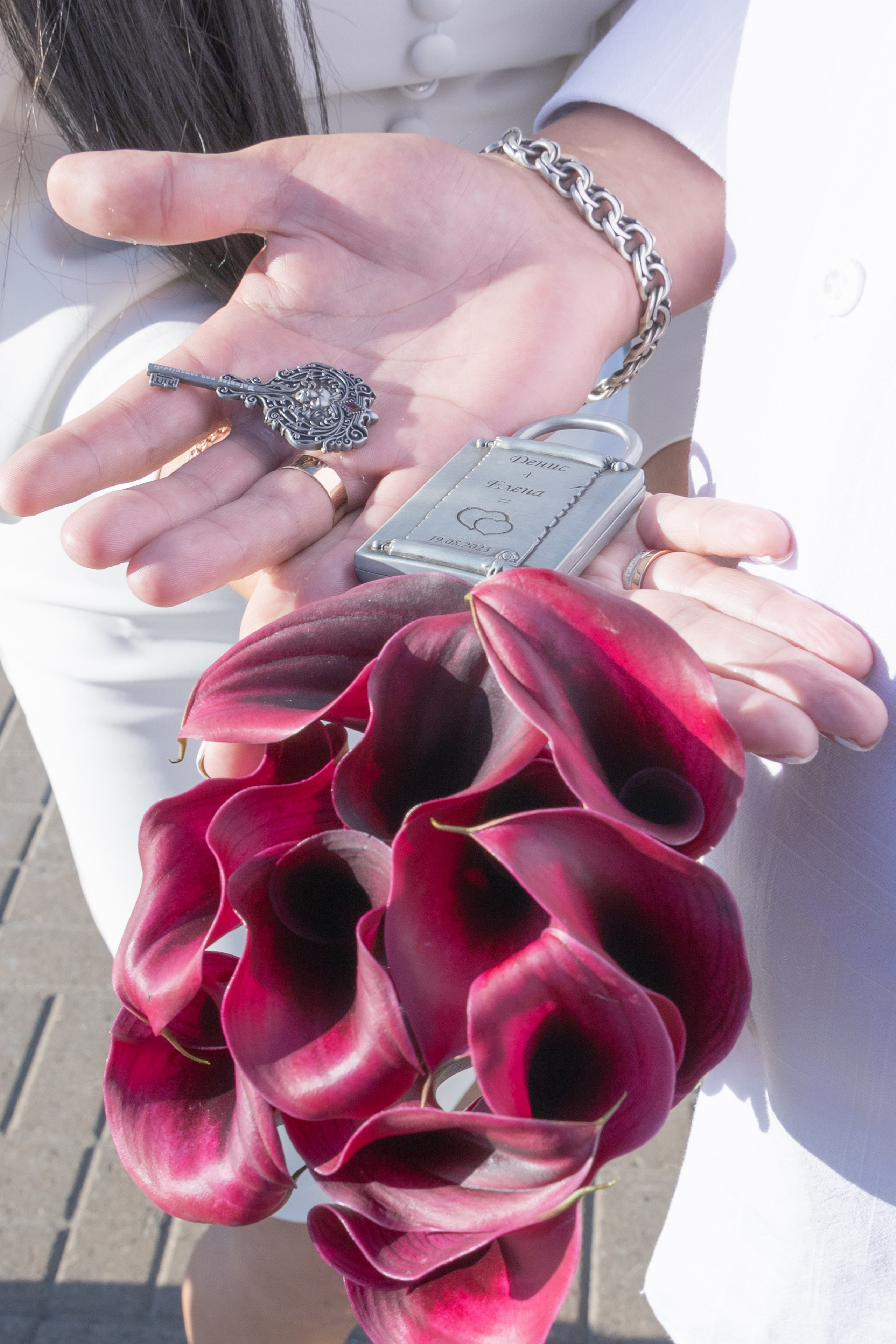 Букет калл и ключ от замка, который повесили на набрежной жених с невестой