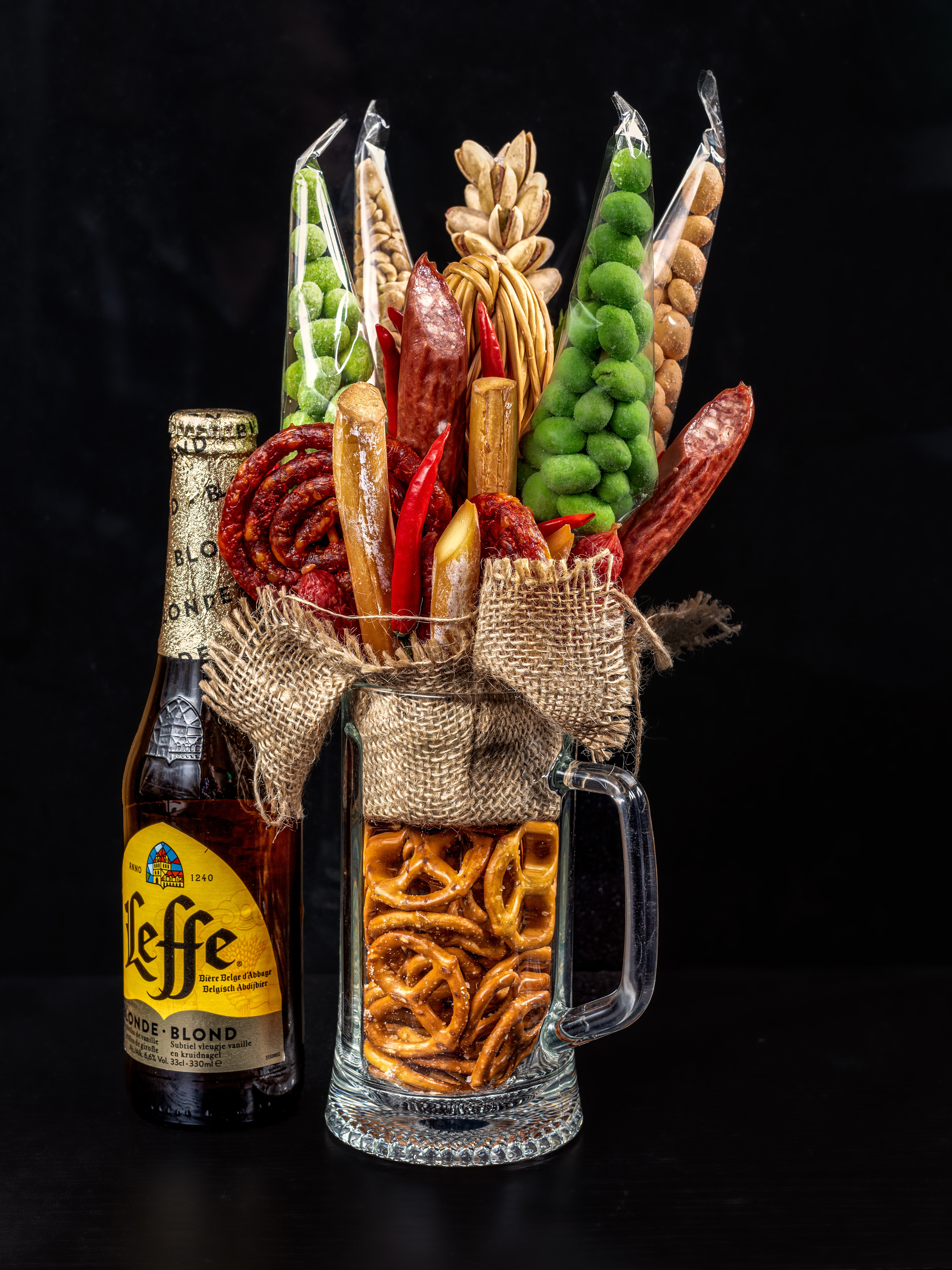 Пивная кружка с закуской в ней и бутылка пива