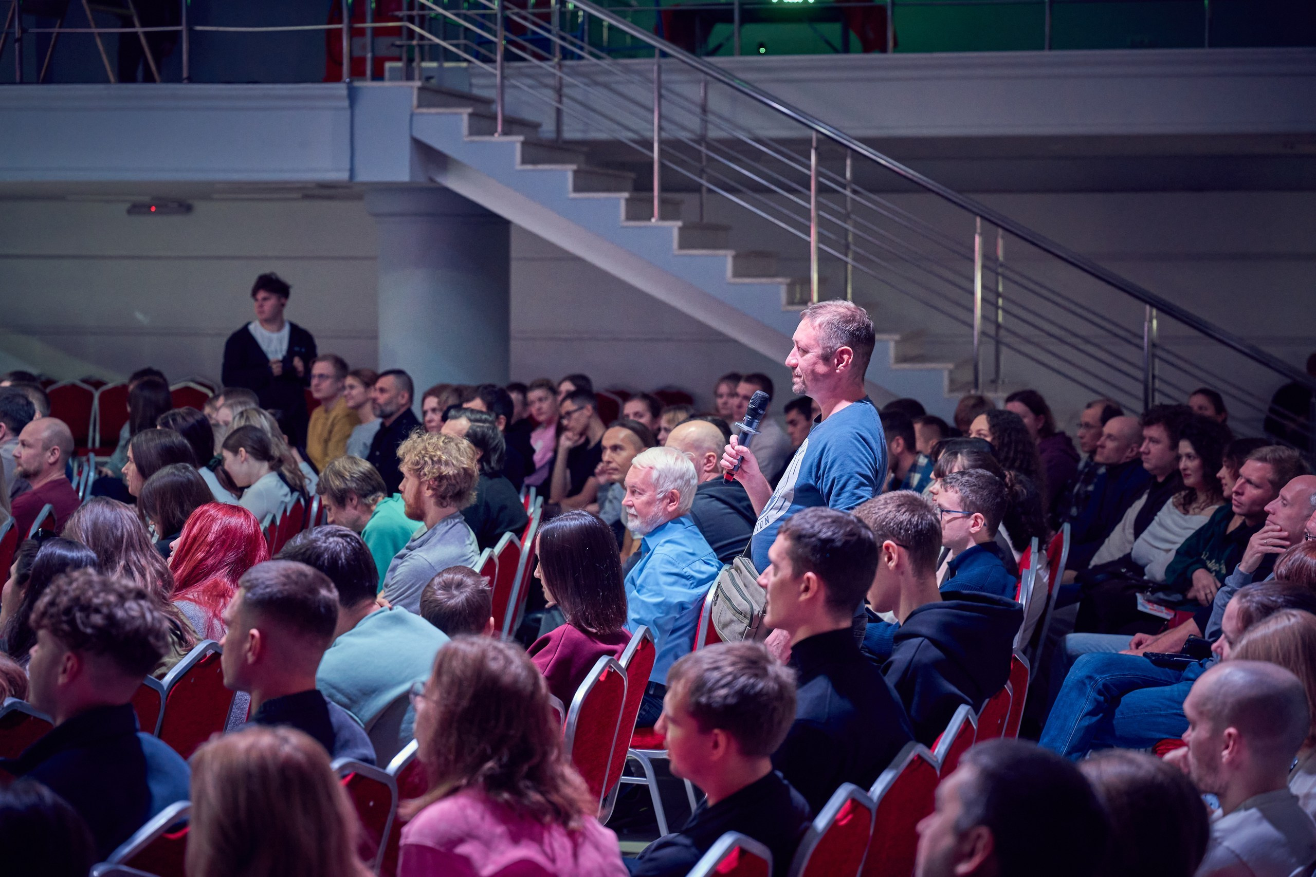 человек встал и задаёт вопрос лектору