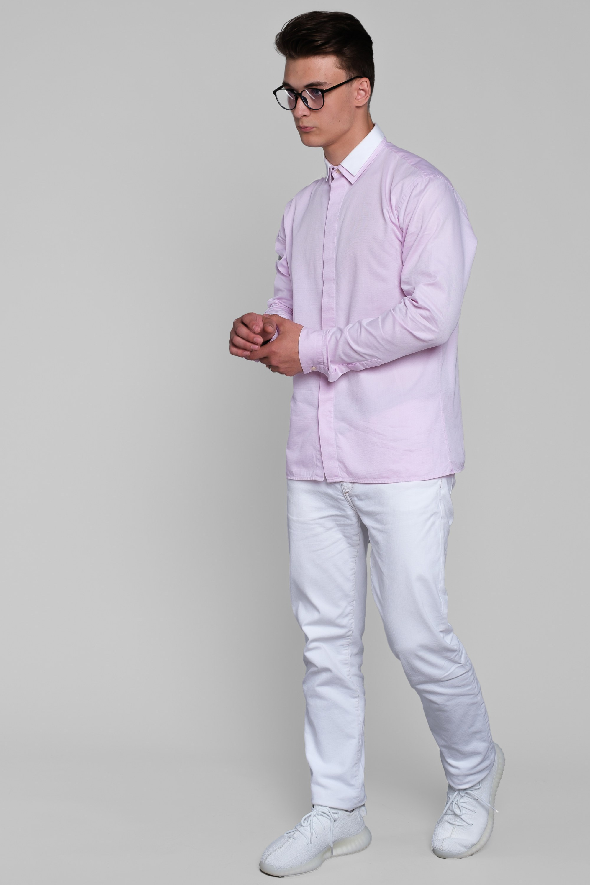 Молодой человек идёт в розовой рубашке в очках и белых ботинках.  Фото для маркетплейсов