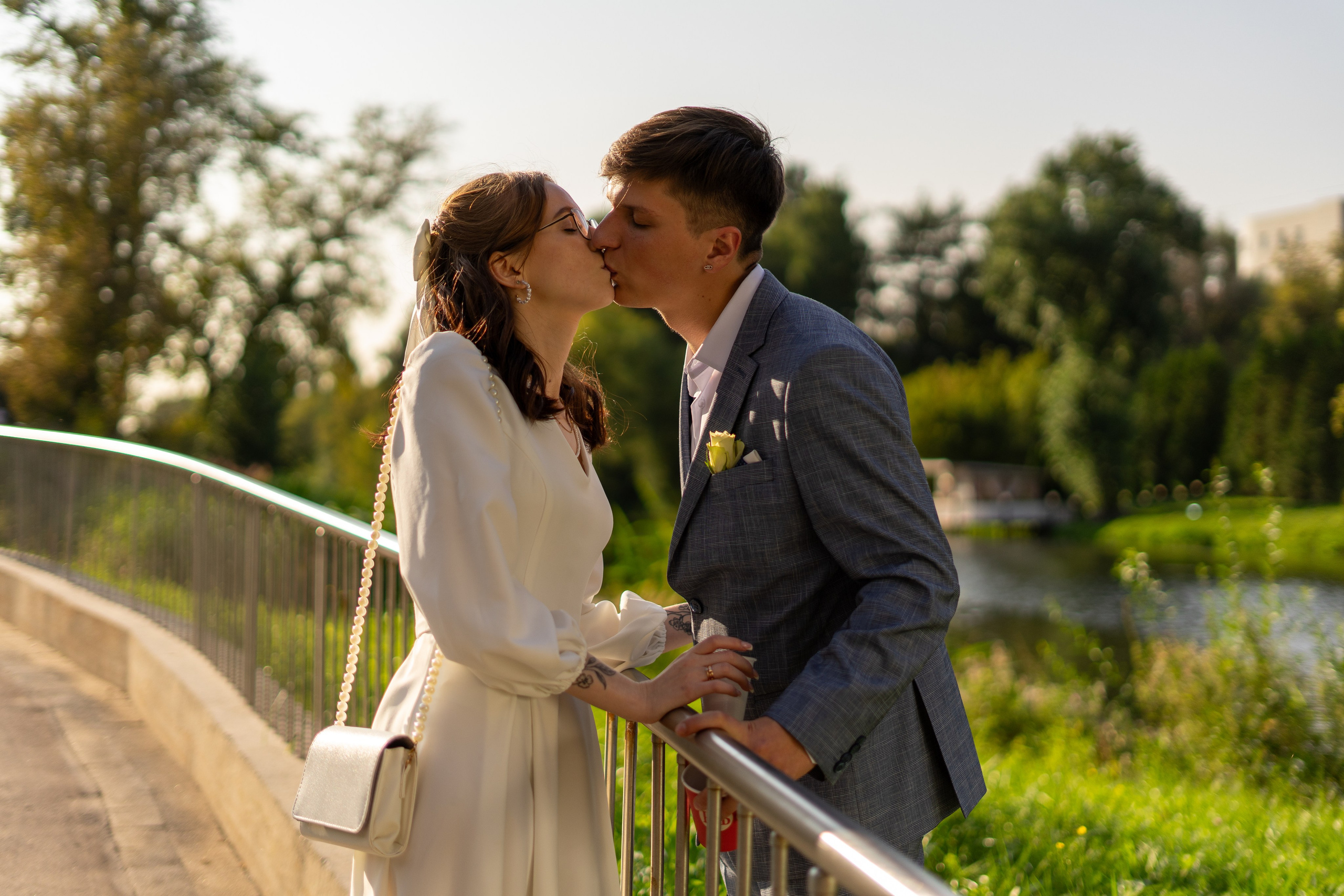 Молодожены целуются на мосту