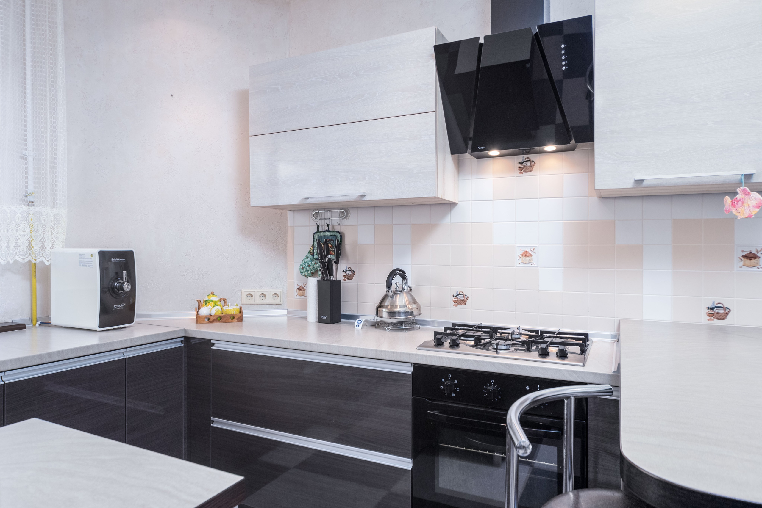 Варочная панель, вытяжка и система хранения на кухне в коттедже 