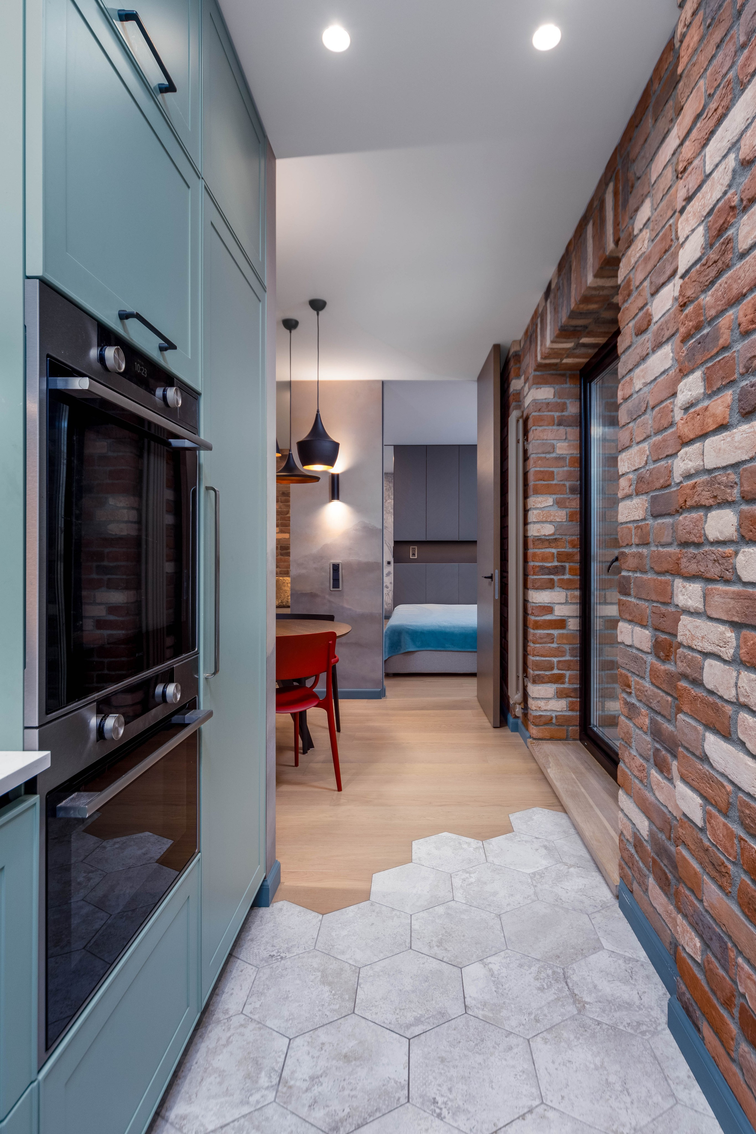 Зона кухни и зона приема пищи с проходом в мастер-спальню в четырехкомнатной квартире в Минске