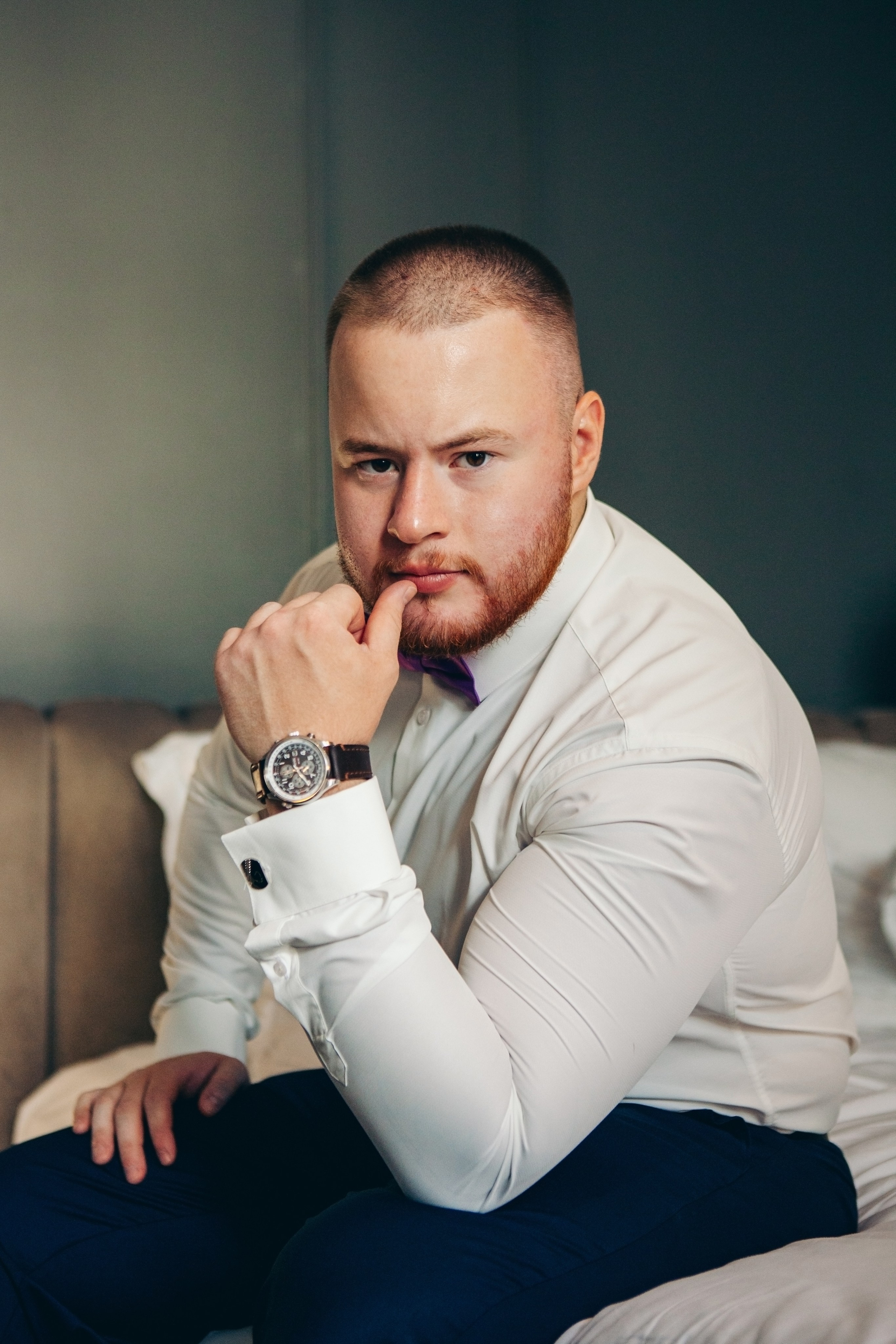 фотосессия жениха в отеле hartwell, сидит на кровати в номере