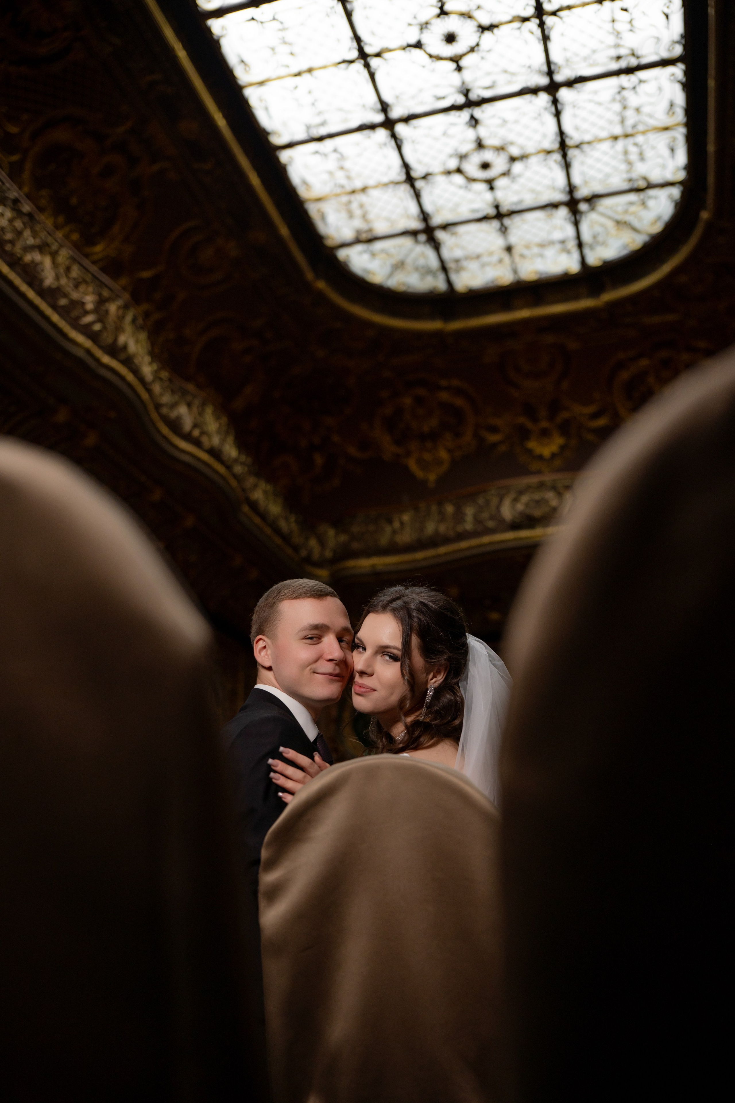 Свадебная фотосессия в Санкт-Петербурге в Особняке Половцева или Дом Архитектора. Невеста сидит на стуле, а жених сидит рядом  в зале театра.