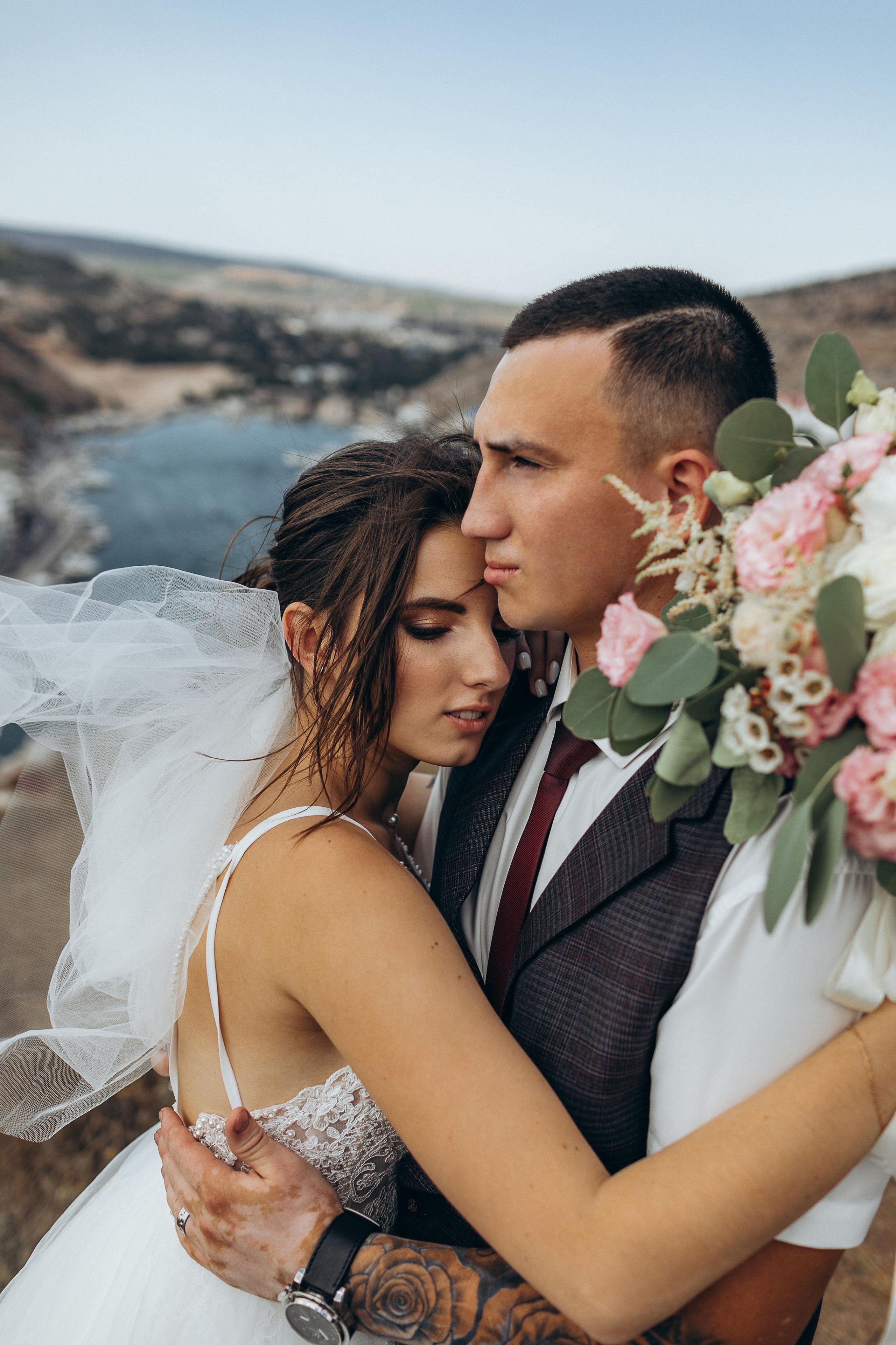 Нежные объятия мужа и жены в теплый день на берегу моря. Медовый месяц в Крыму.