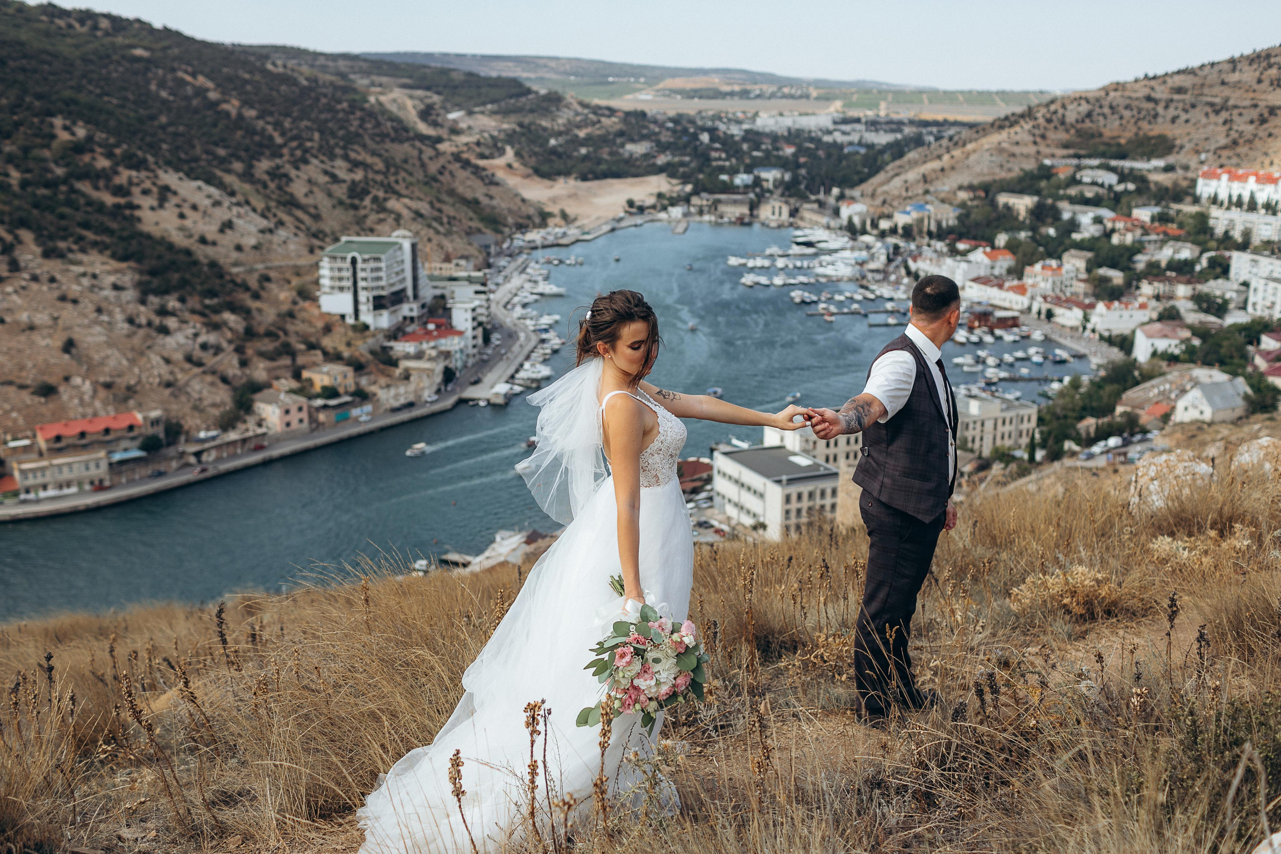 Красивая бухта, жених держит заруку свою красивую невесту. Фото в Крыму.