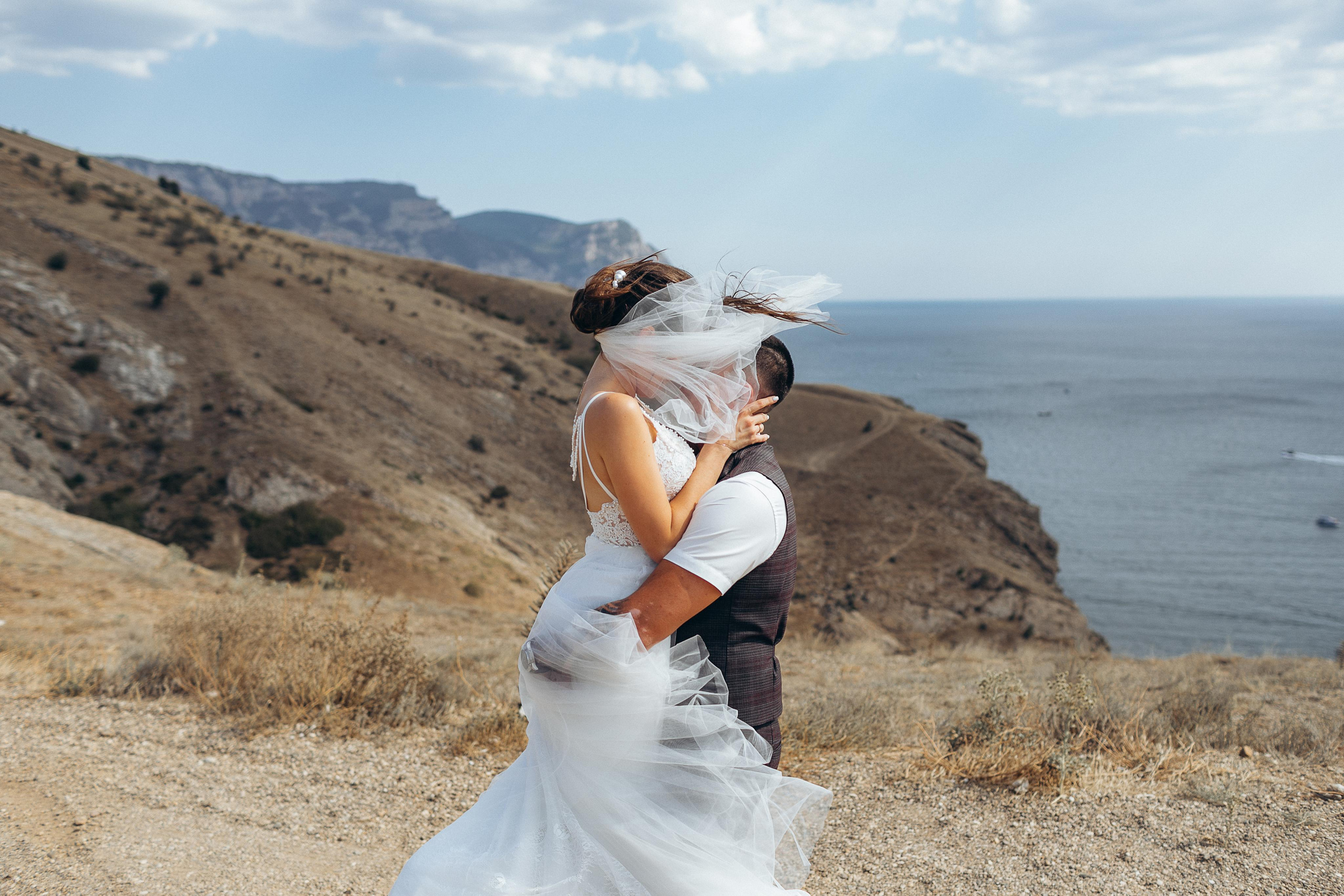 Пара кружиться в объятиях на фоне гор. Отдых в Ялте.