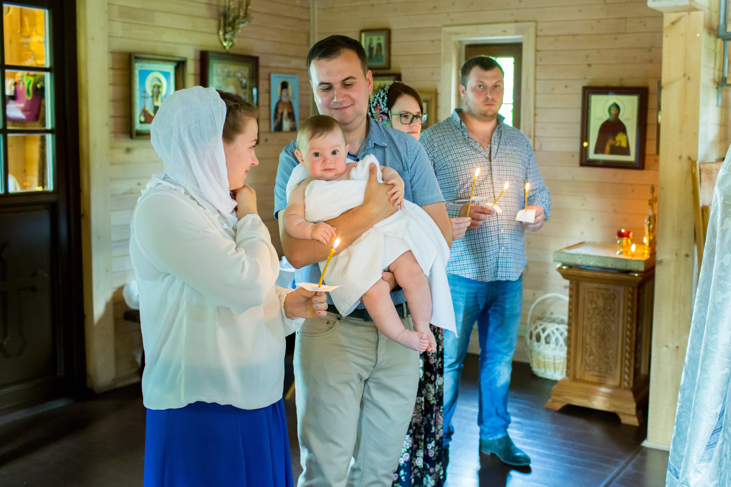 Семья с ребёнком во время крещения в храме