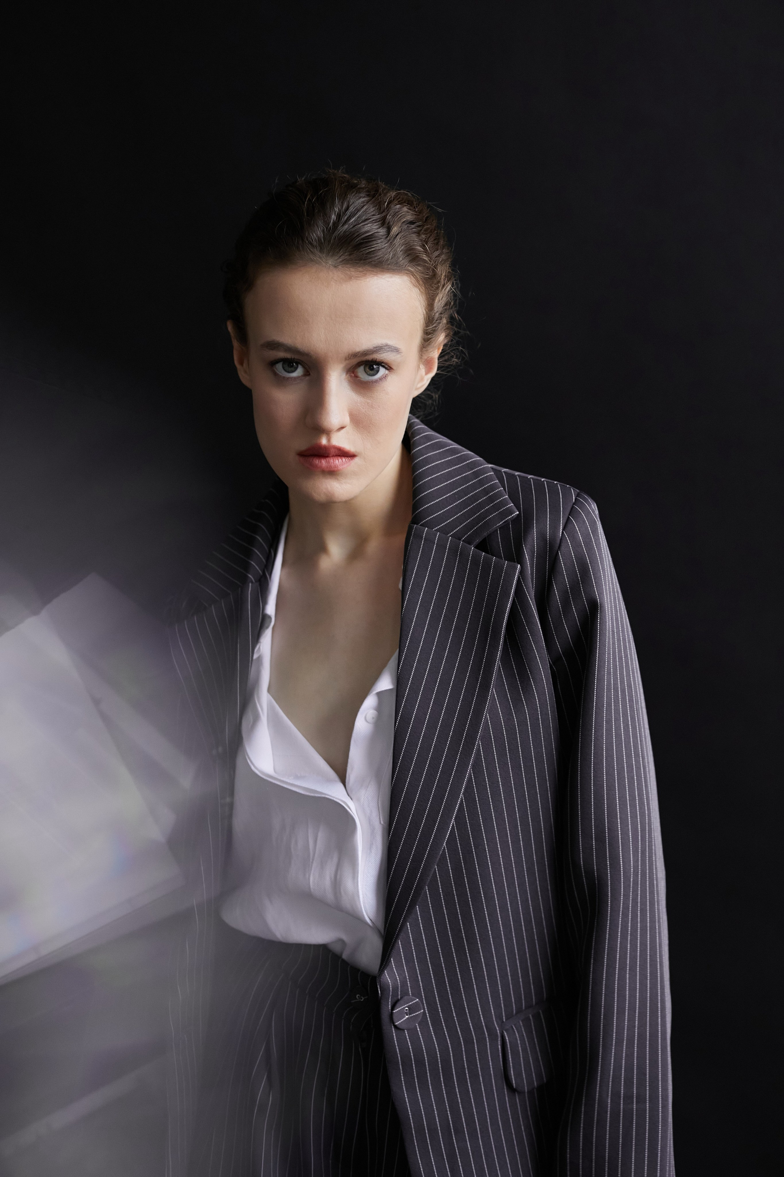 Фотограф в Москве. Студия. Студийный портрет. Девушка в пиджаке. Девушка на стуле на черном фоне. Красивая девушка в мужском костюме. Женский портрет.