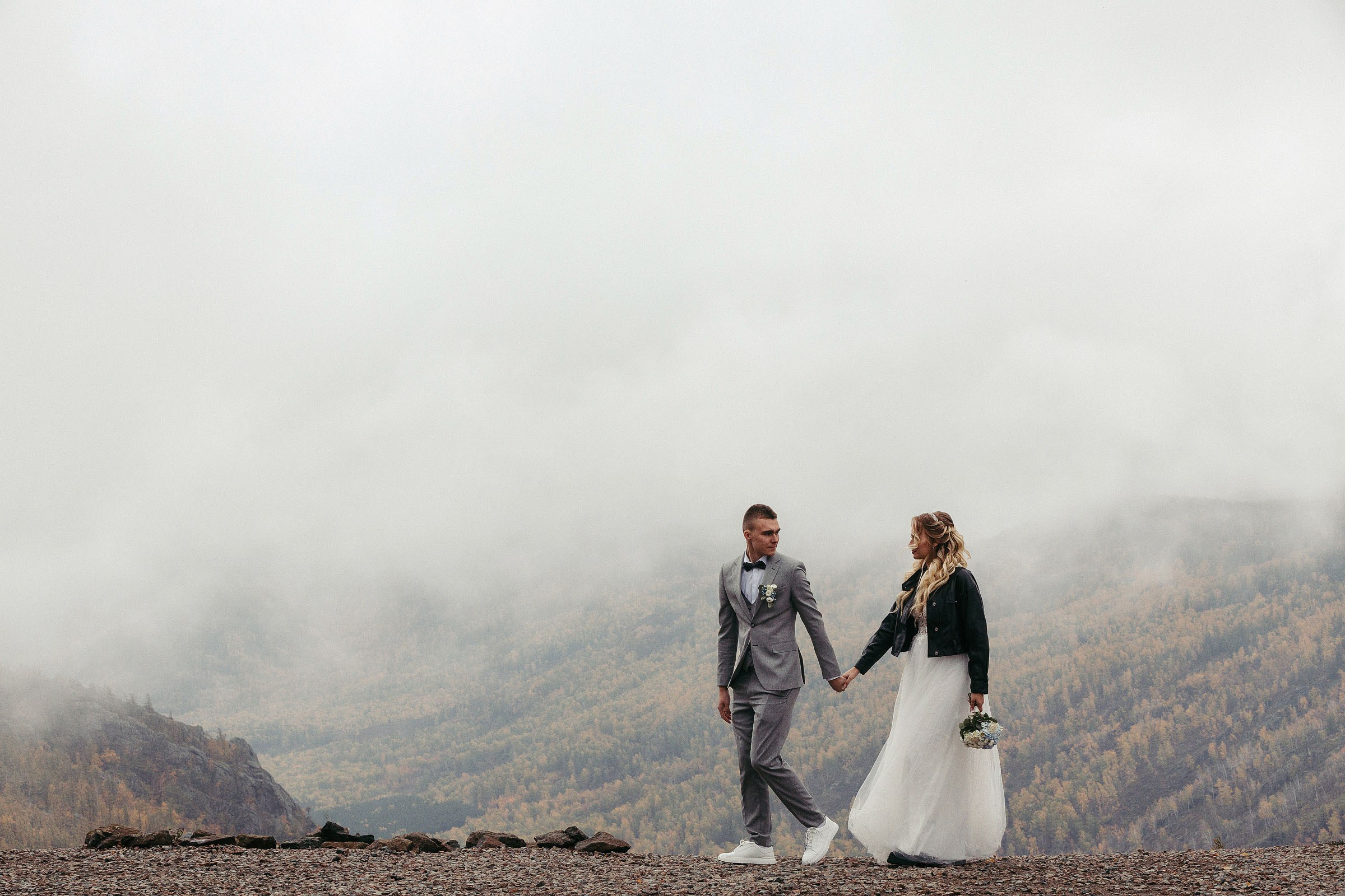 Молодая пара гуляет на вершине горы в тумане