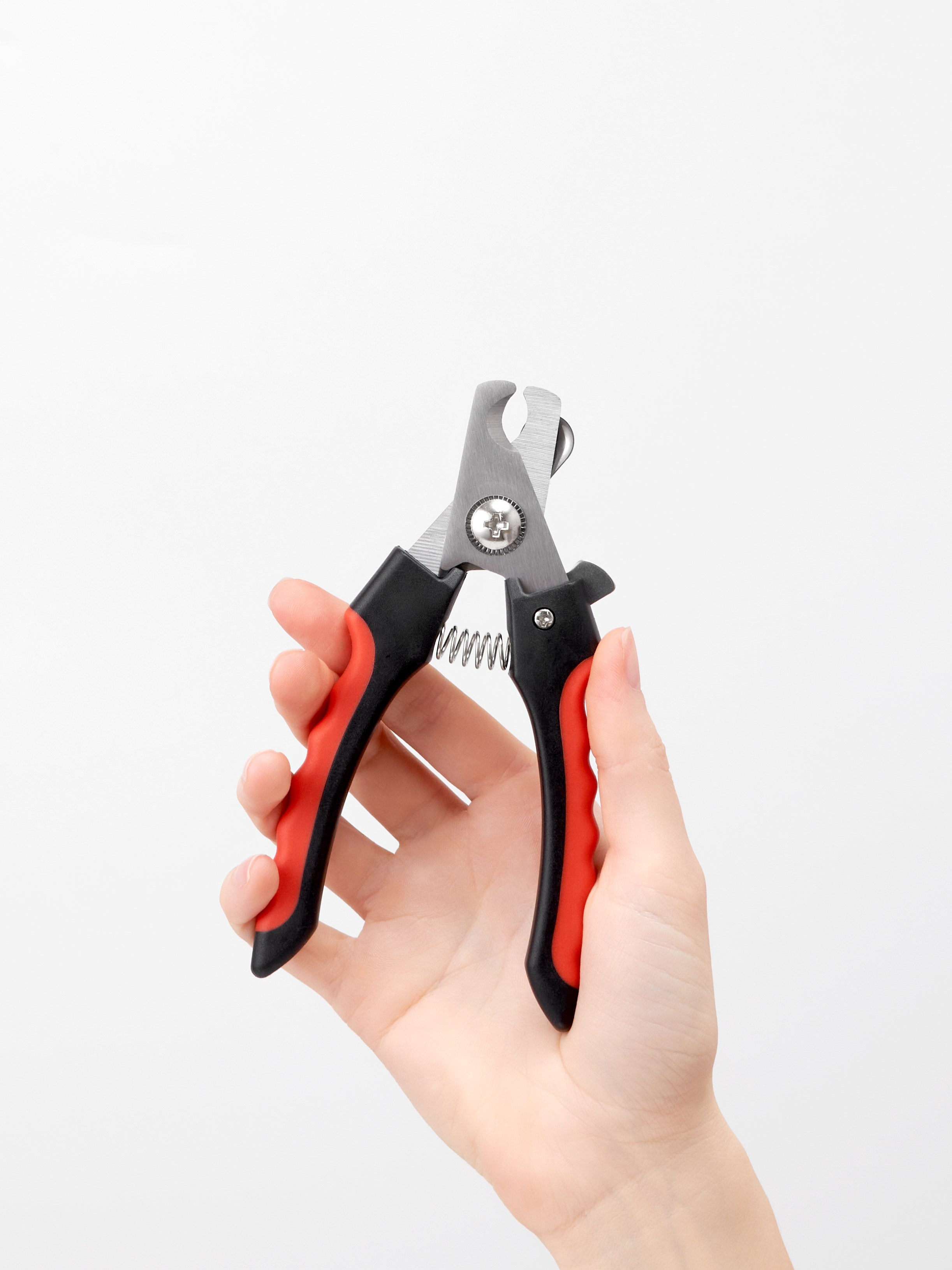 Предметная фотосъёмка красного когтереза для животных в руке модели на белом фоне