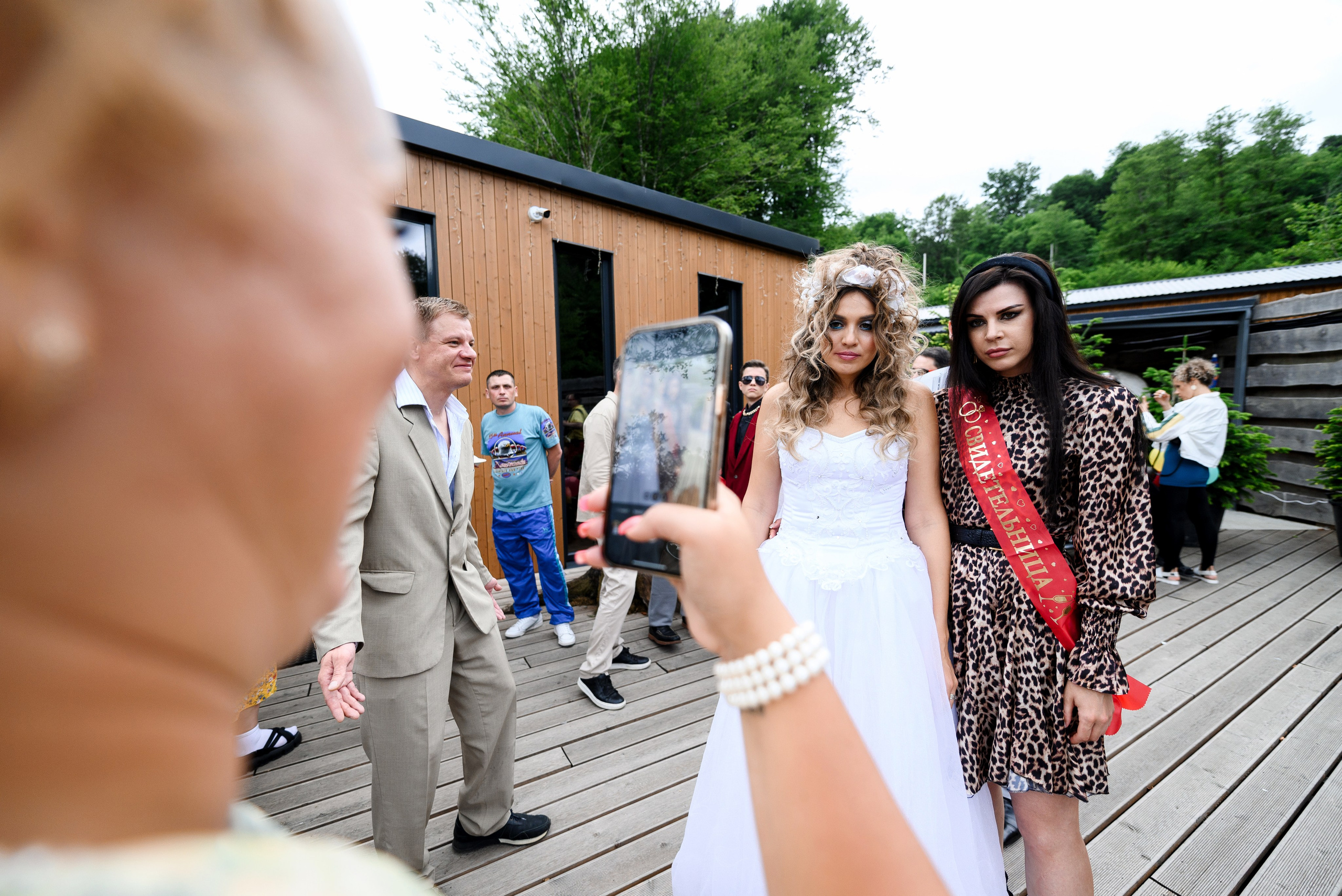 Кто-то фотографирует невесту и свидетельницу на телефон 