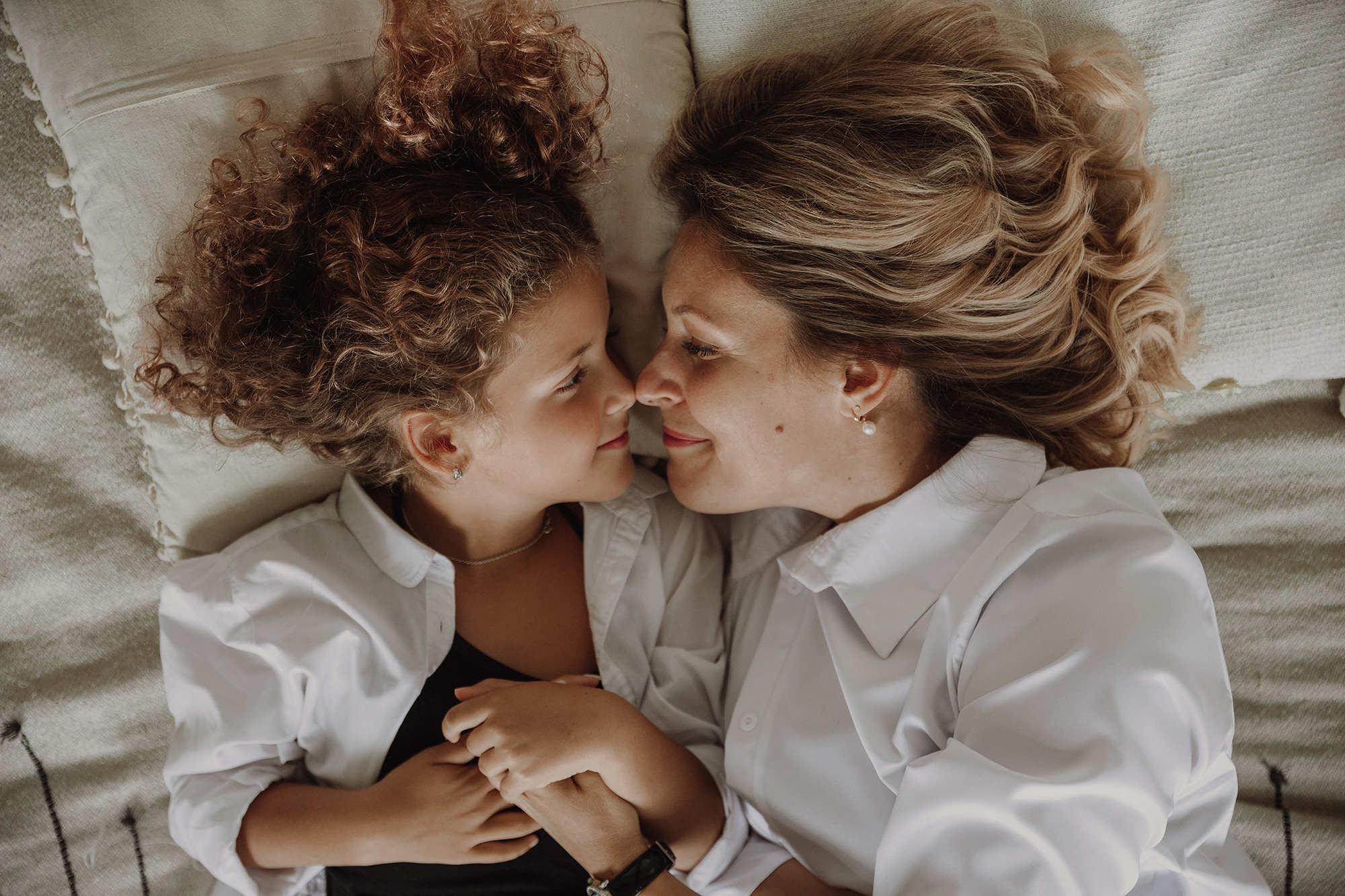 Мама и дочка лежат на кровати, крупный портрет