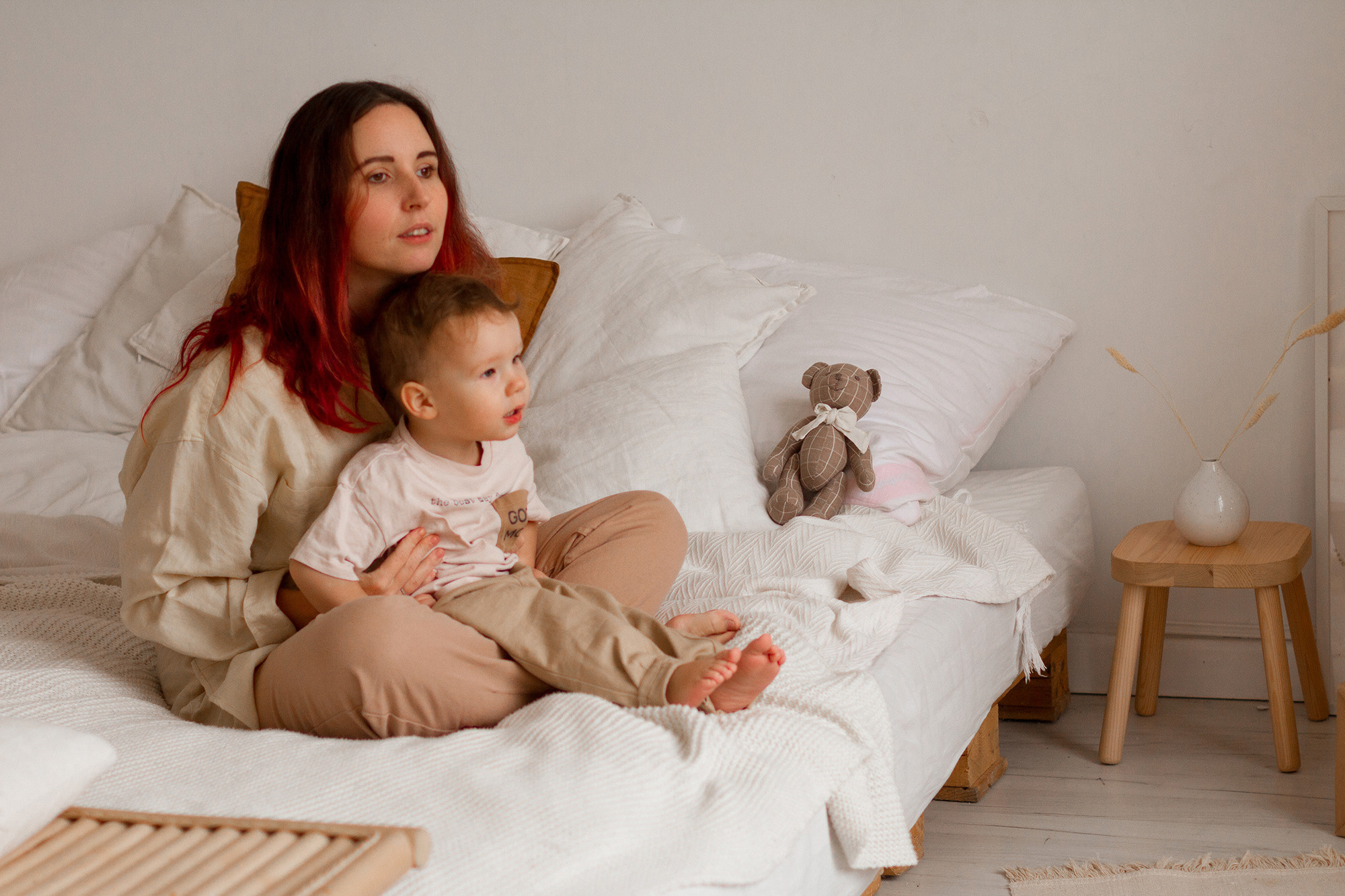 Мама и маленький сын сидят на кровати