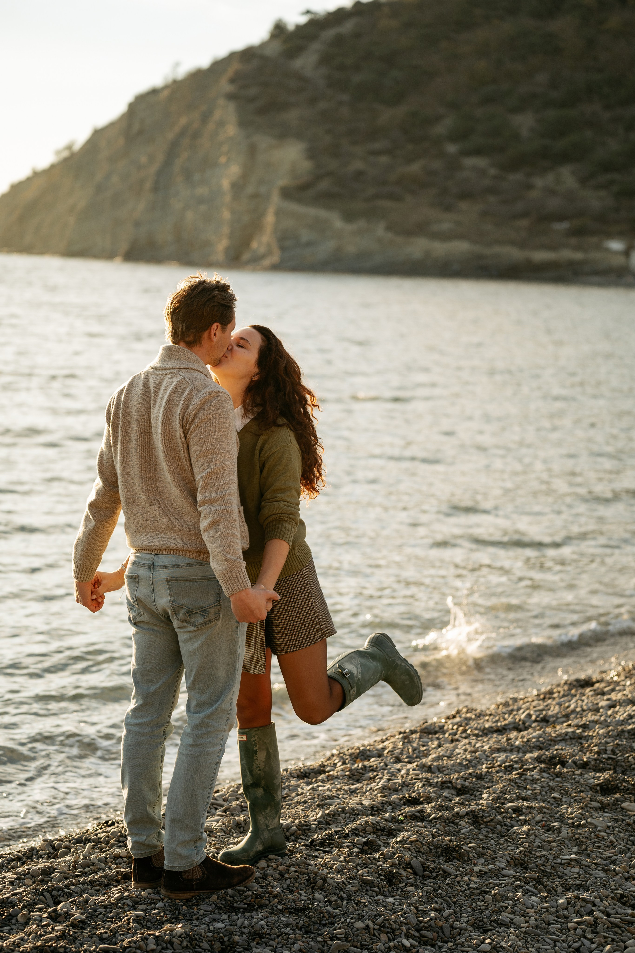 Семейная фотосессия в Новороссийске на закате. Силуэты мамы, папы, дочки и сына на фоне уходящего за горизонт солнца.