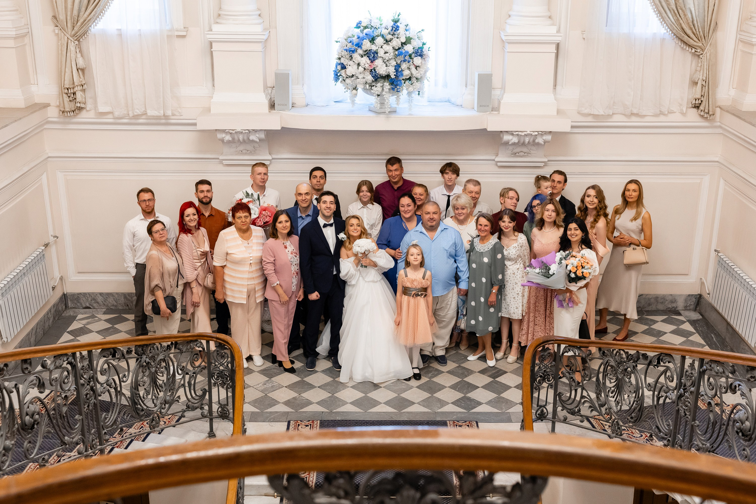 Общее фото жениха и невесты с гостями на парадной лестнице во дворце бракосочетания №2 в Санкт-Петербурге